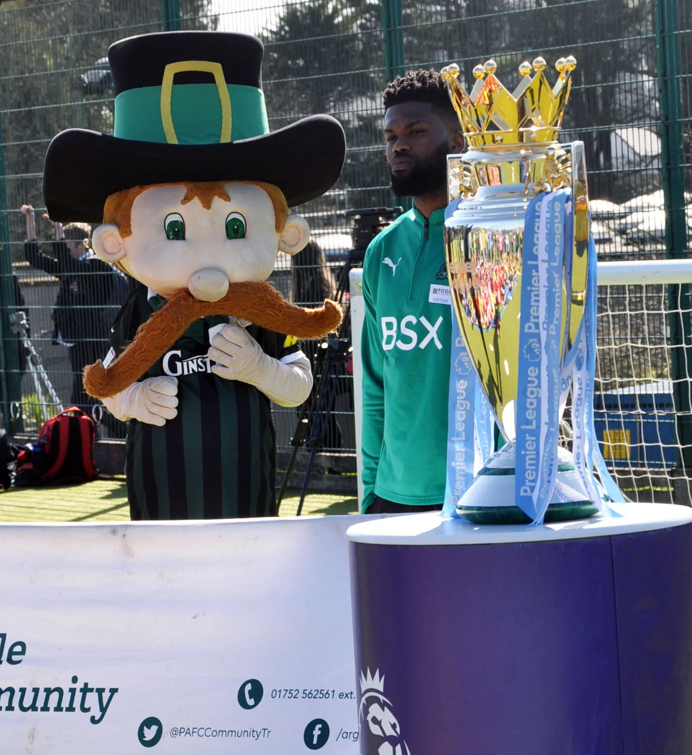 Plymouth Argyle player Joel Grant with mascot Pilgrim Pete and the Premier League Cup.