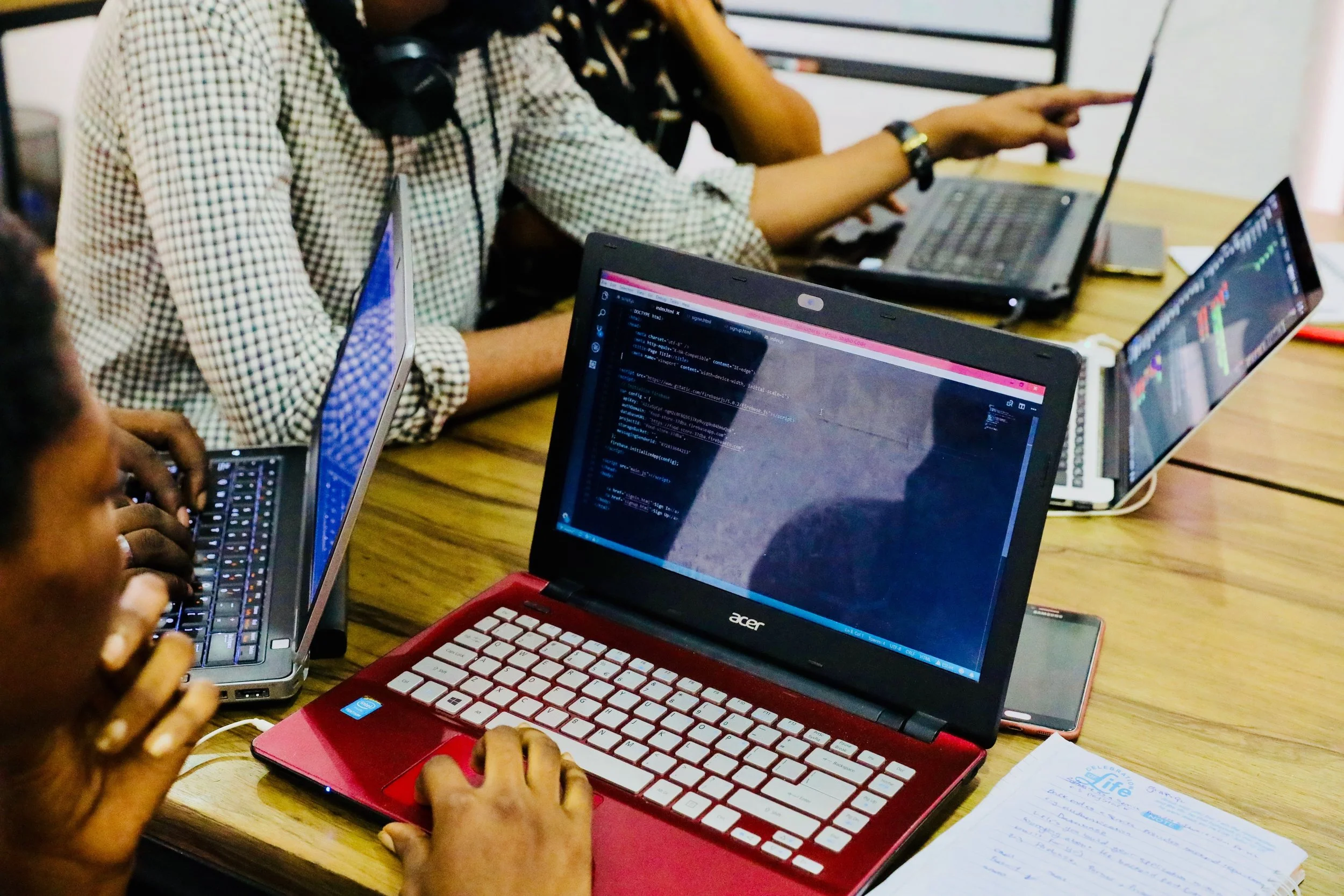 View of Person Writing Code on a Red Laptop