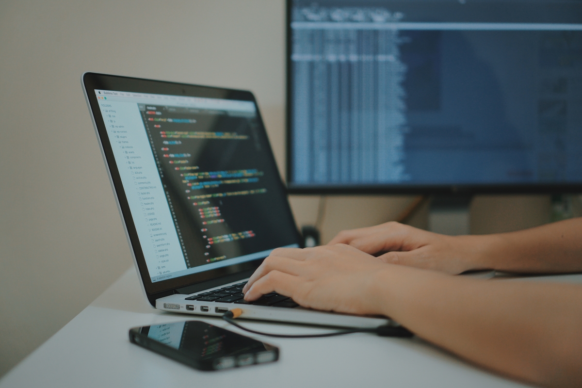 Mobile App Developer Writing Code on His Laptop