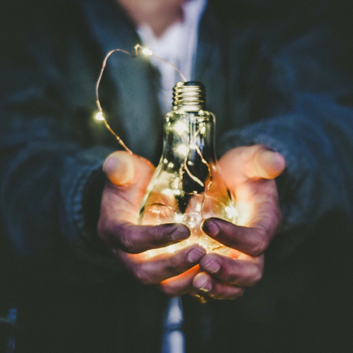 Man Holding Lightbulb in His Hands