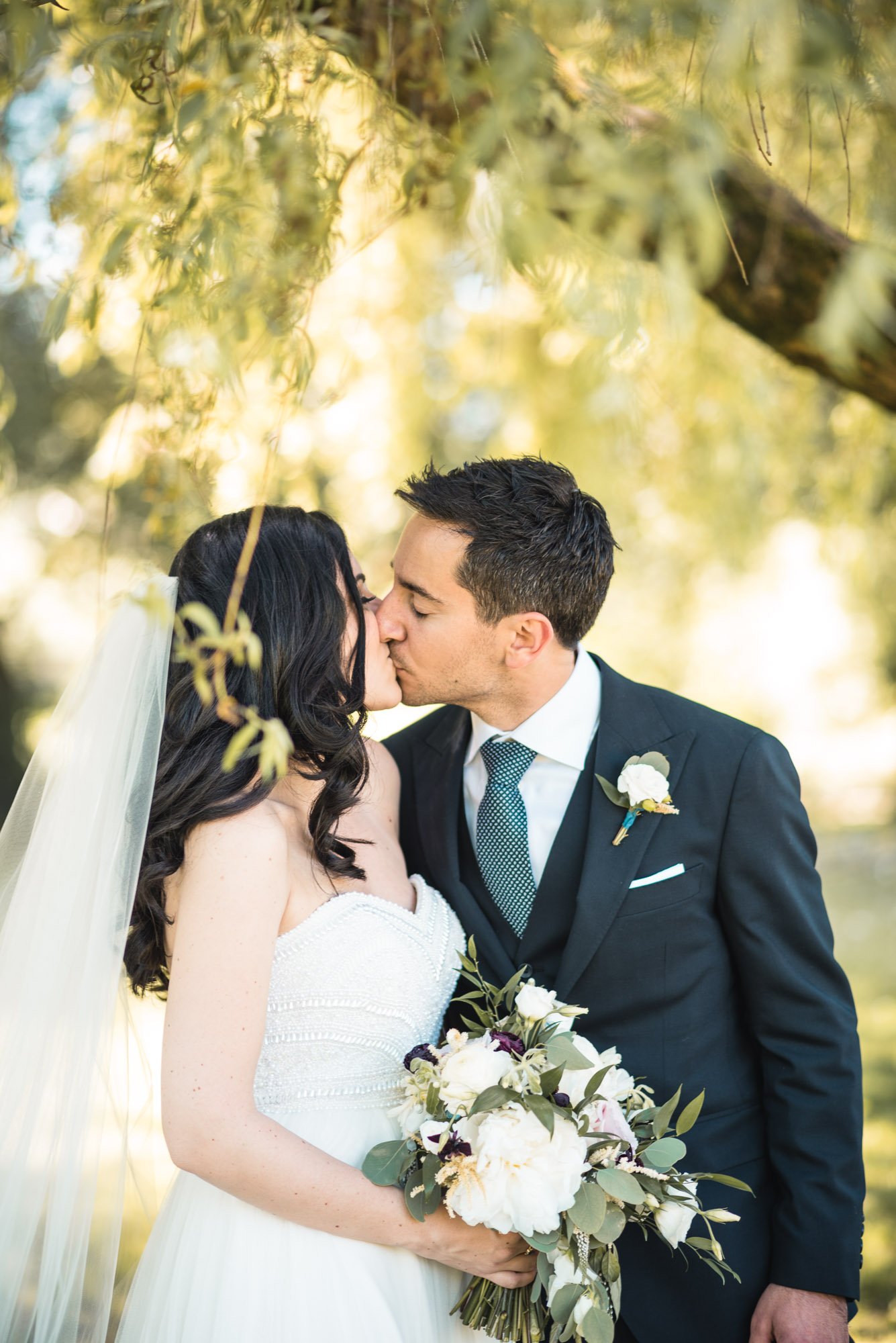 Bride and Groom at the park kiss