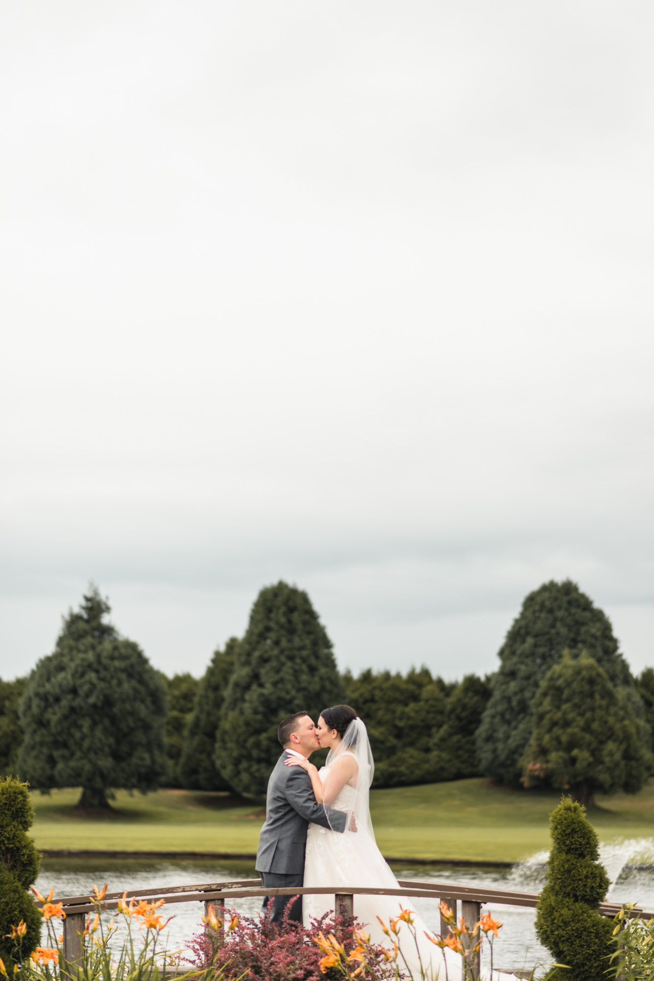 Bride and Groom kissing on bridge