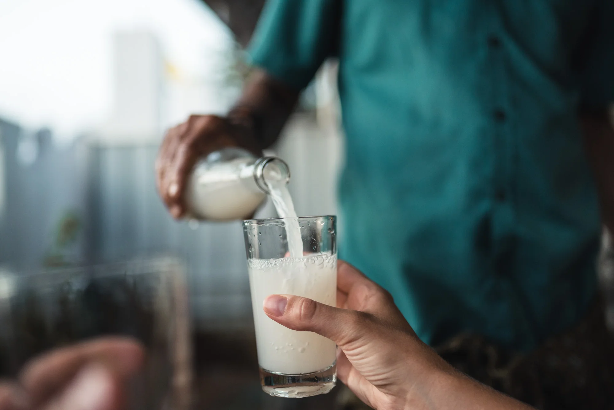 Man pouring toddy into glass