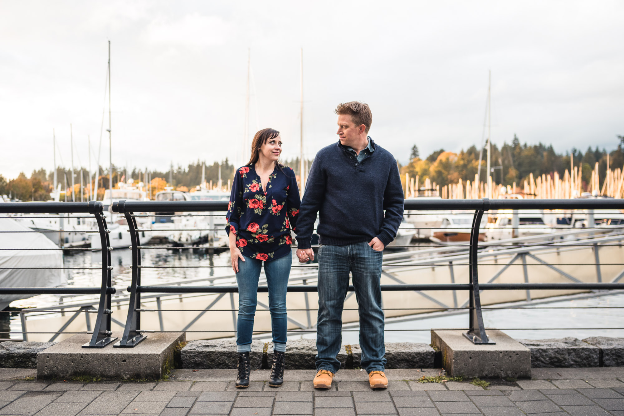 Couple holds hands on seawall