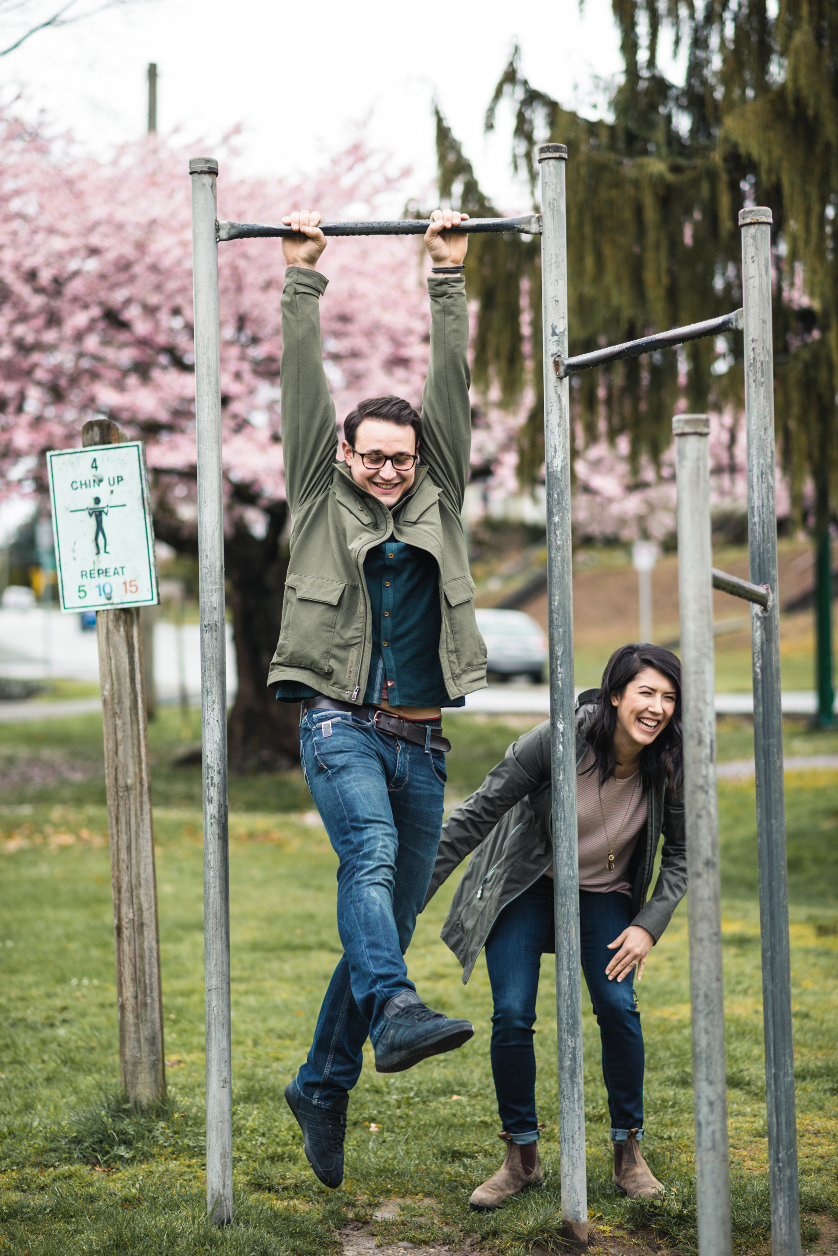 Couple swinging on bars at playground