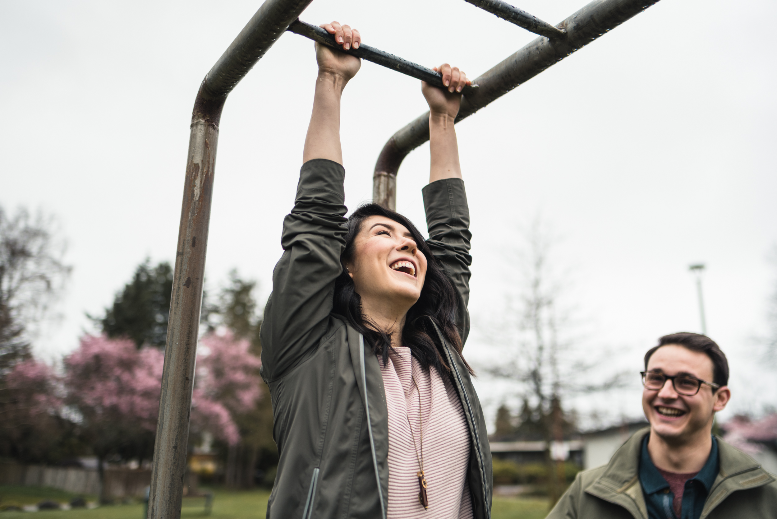 Couple swinging on bars at playground