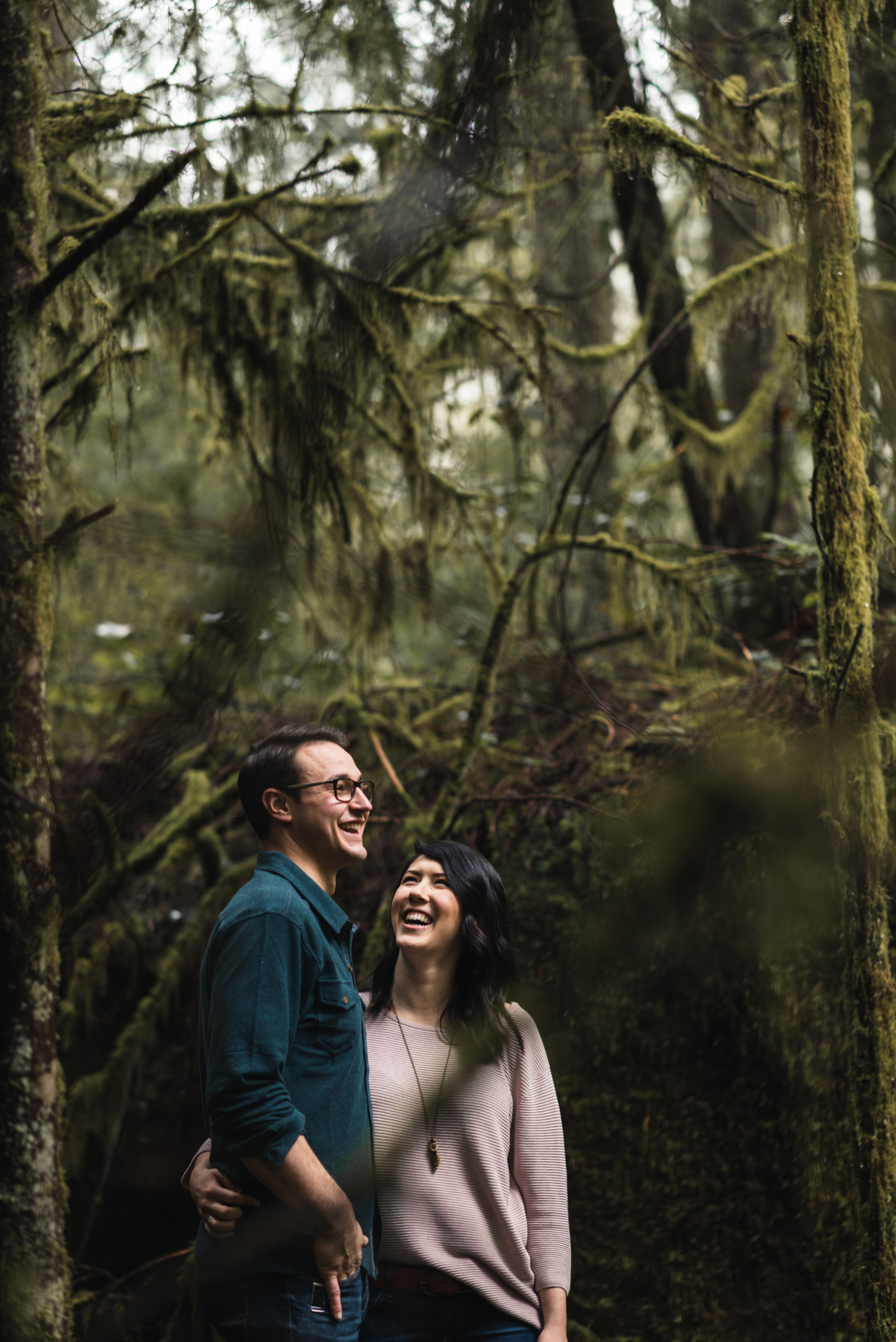 Couple embracing and laughing in forest