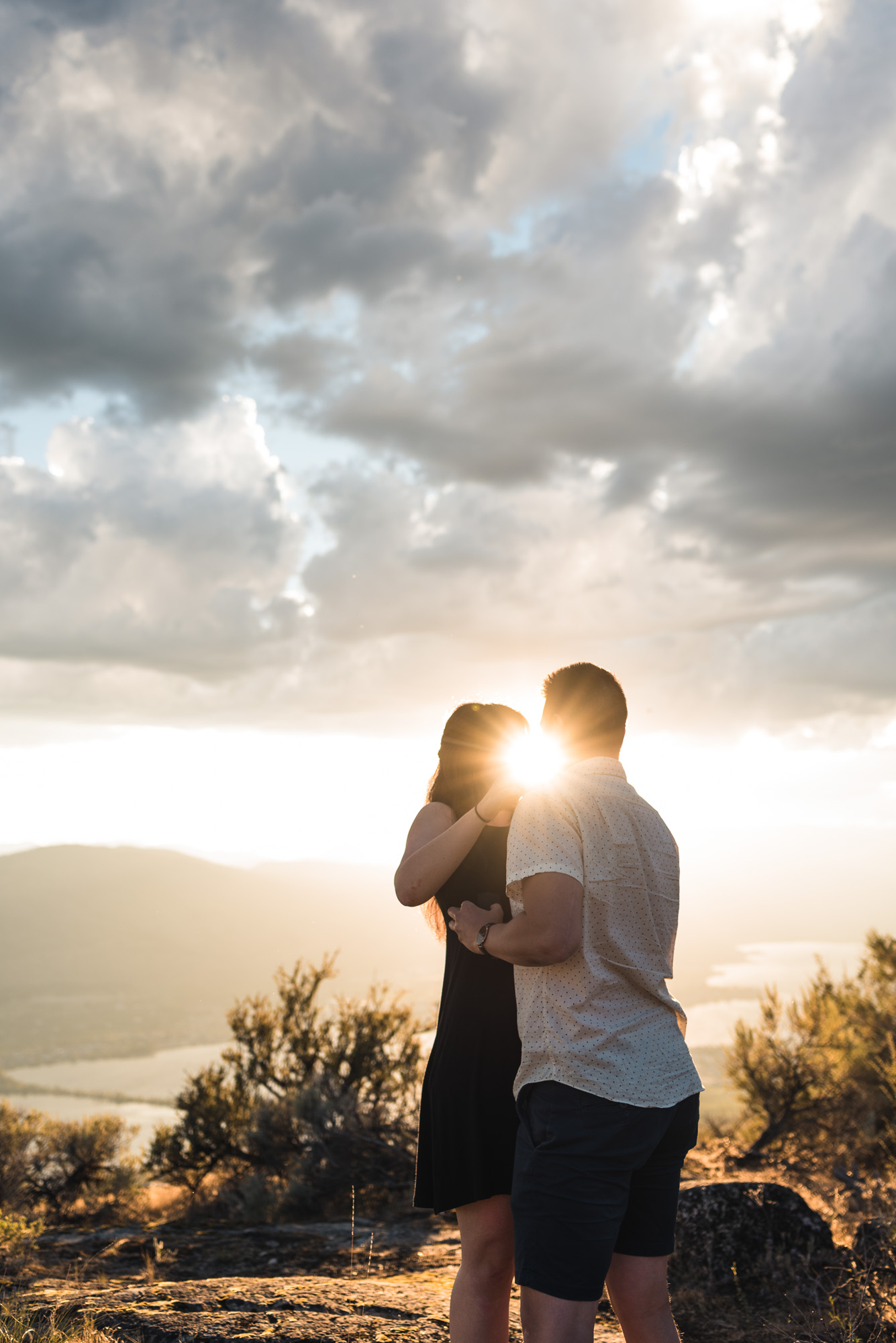 Engaged couple embraces with sunset on Anarchist Mountain, Osoyoos