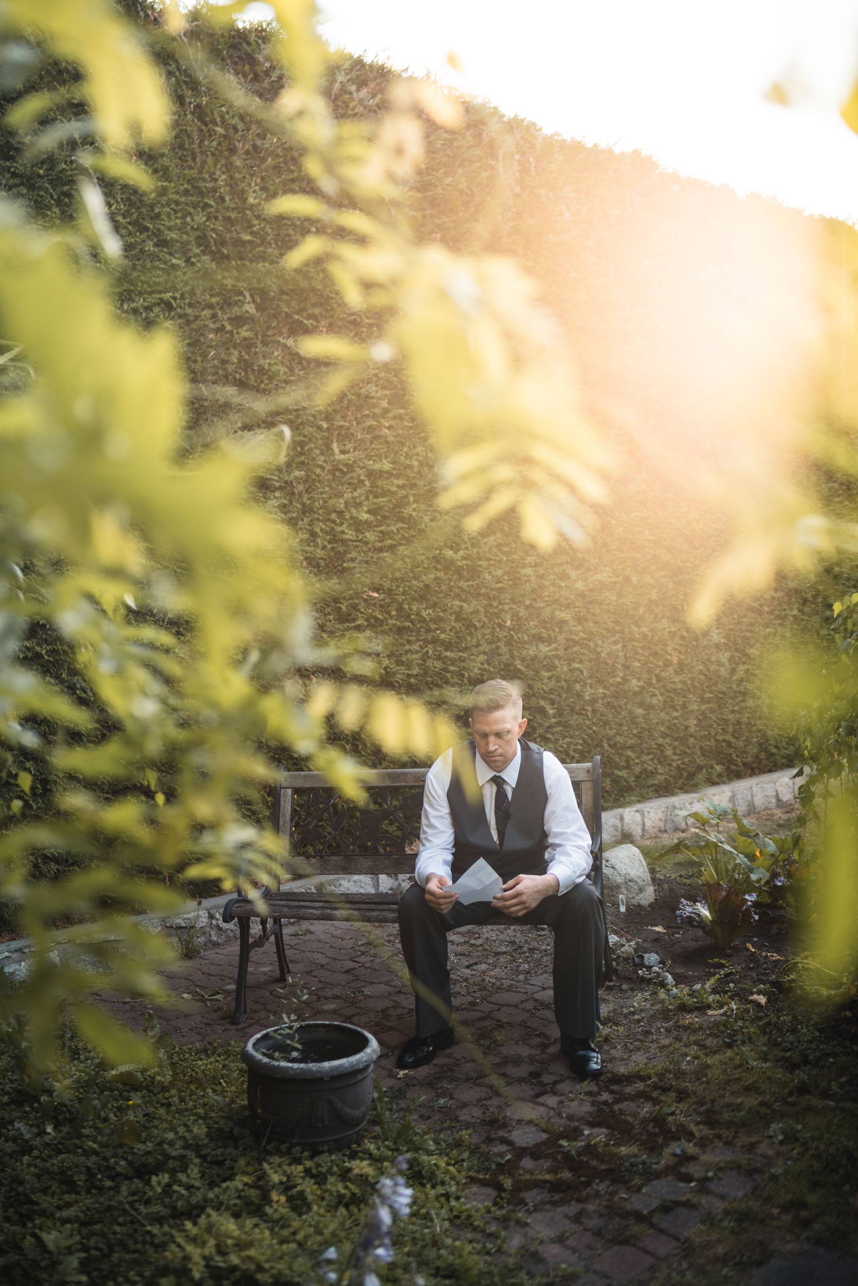 Groom holding letter in garden