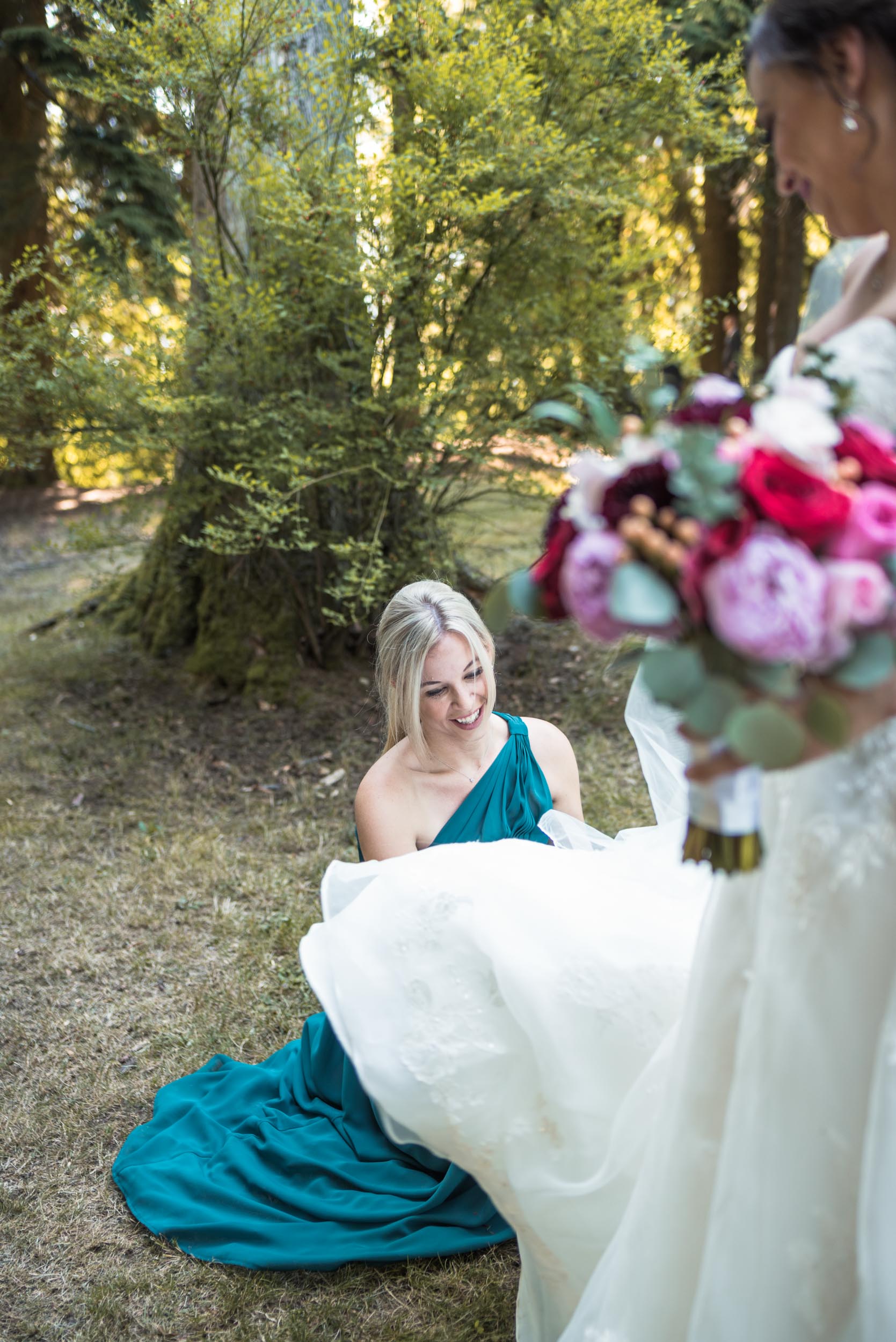 Bride helped with dress by Bridesmaid