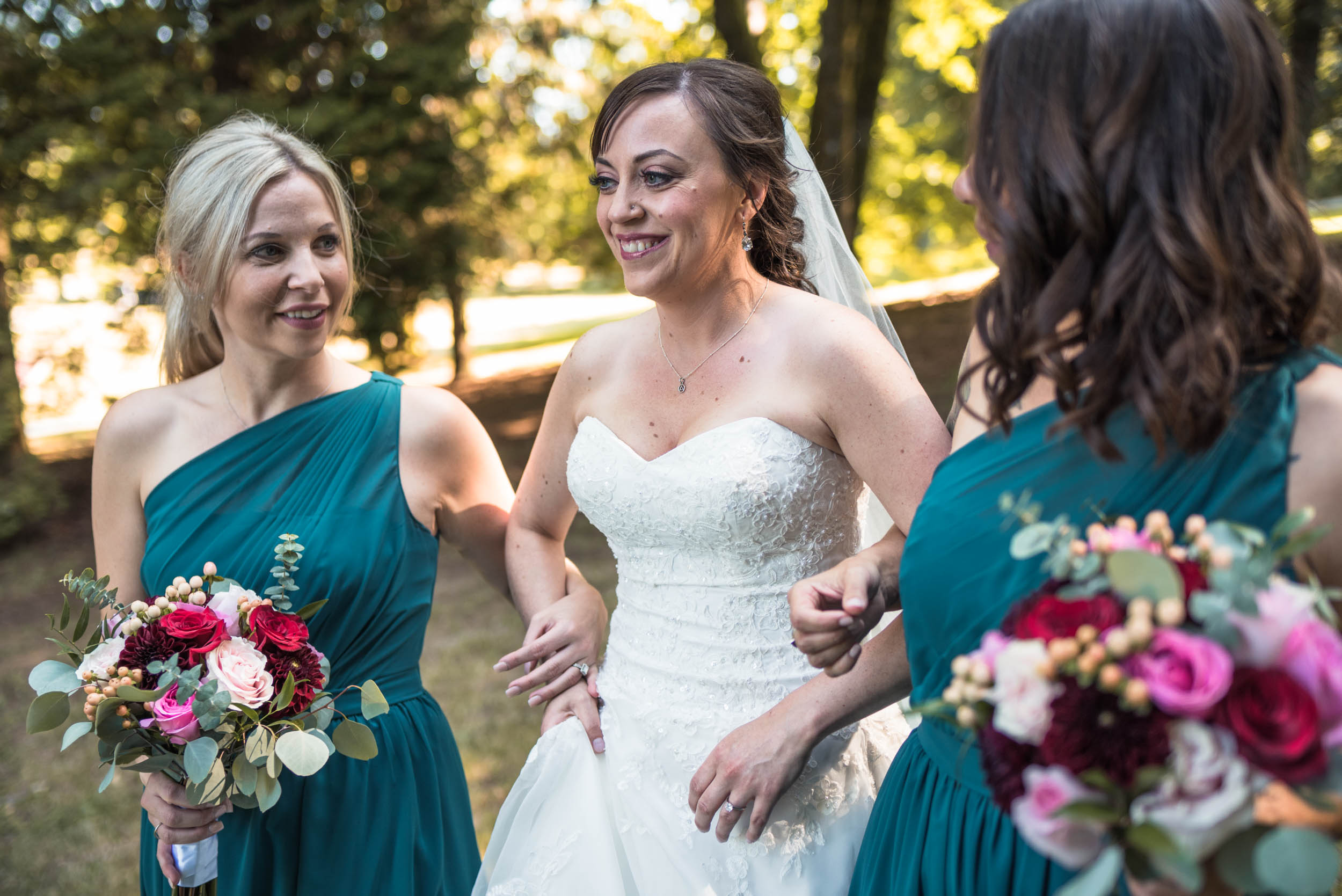 Bride and bridesmaids walk through forest