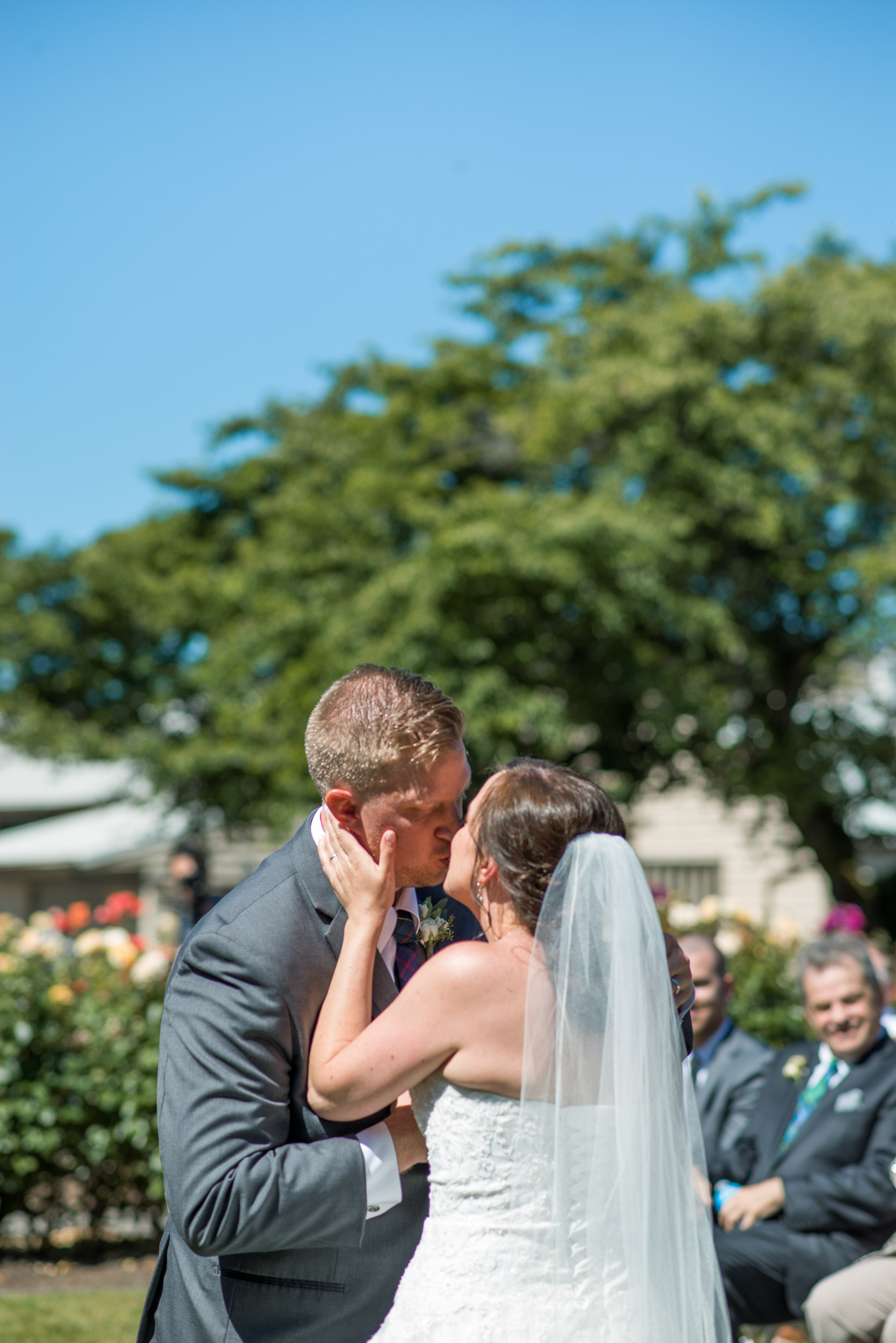 Wedding ceremony in rose garden first kiss