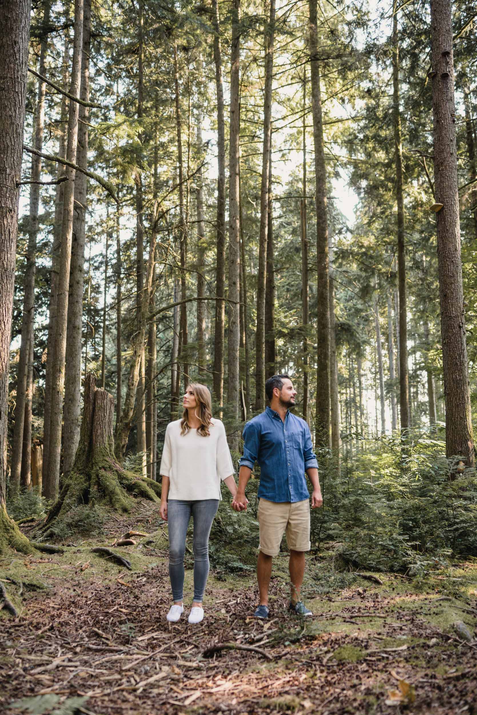 Couple posing with tall trees in the forest