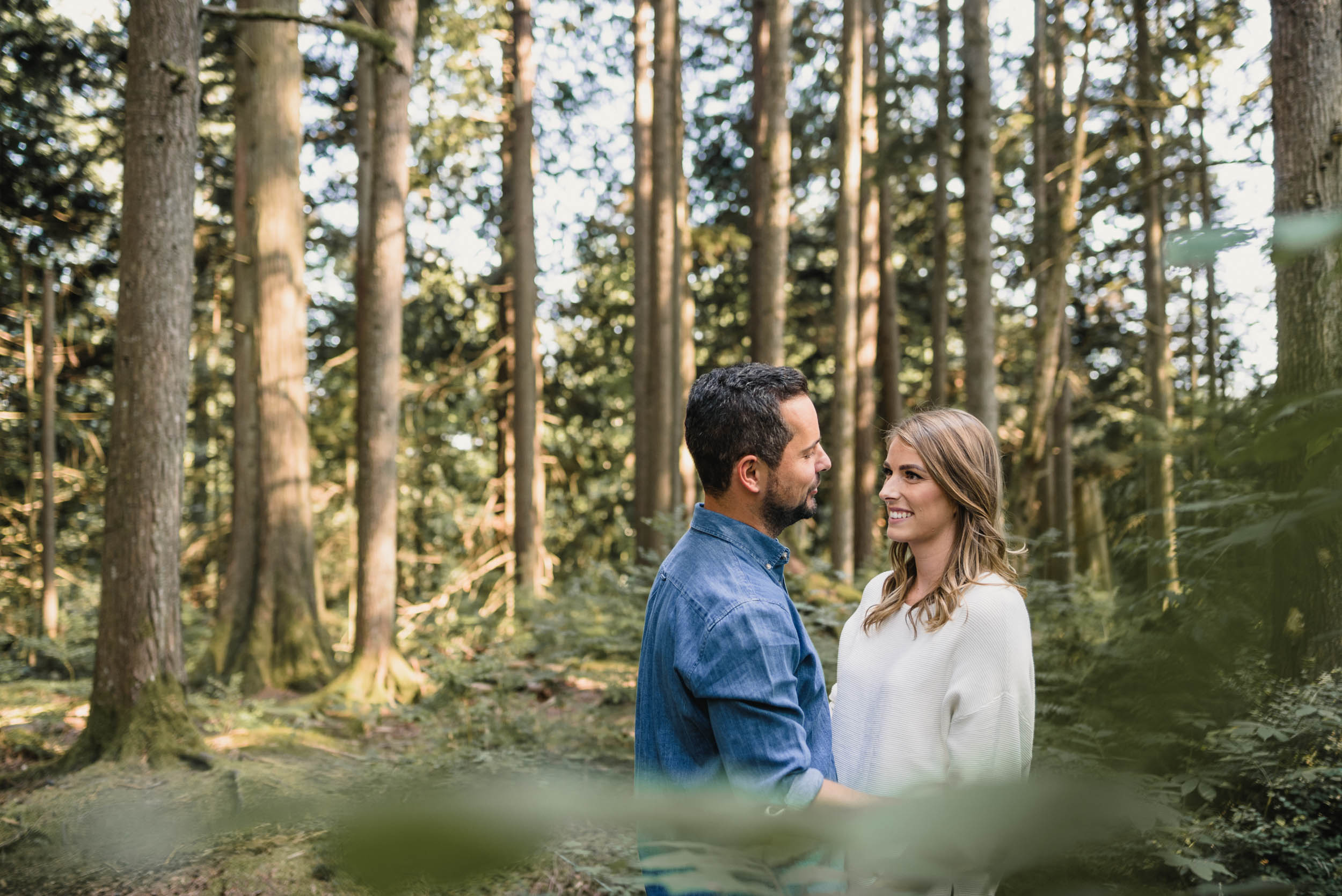 Couple smiling together in forest foliage