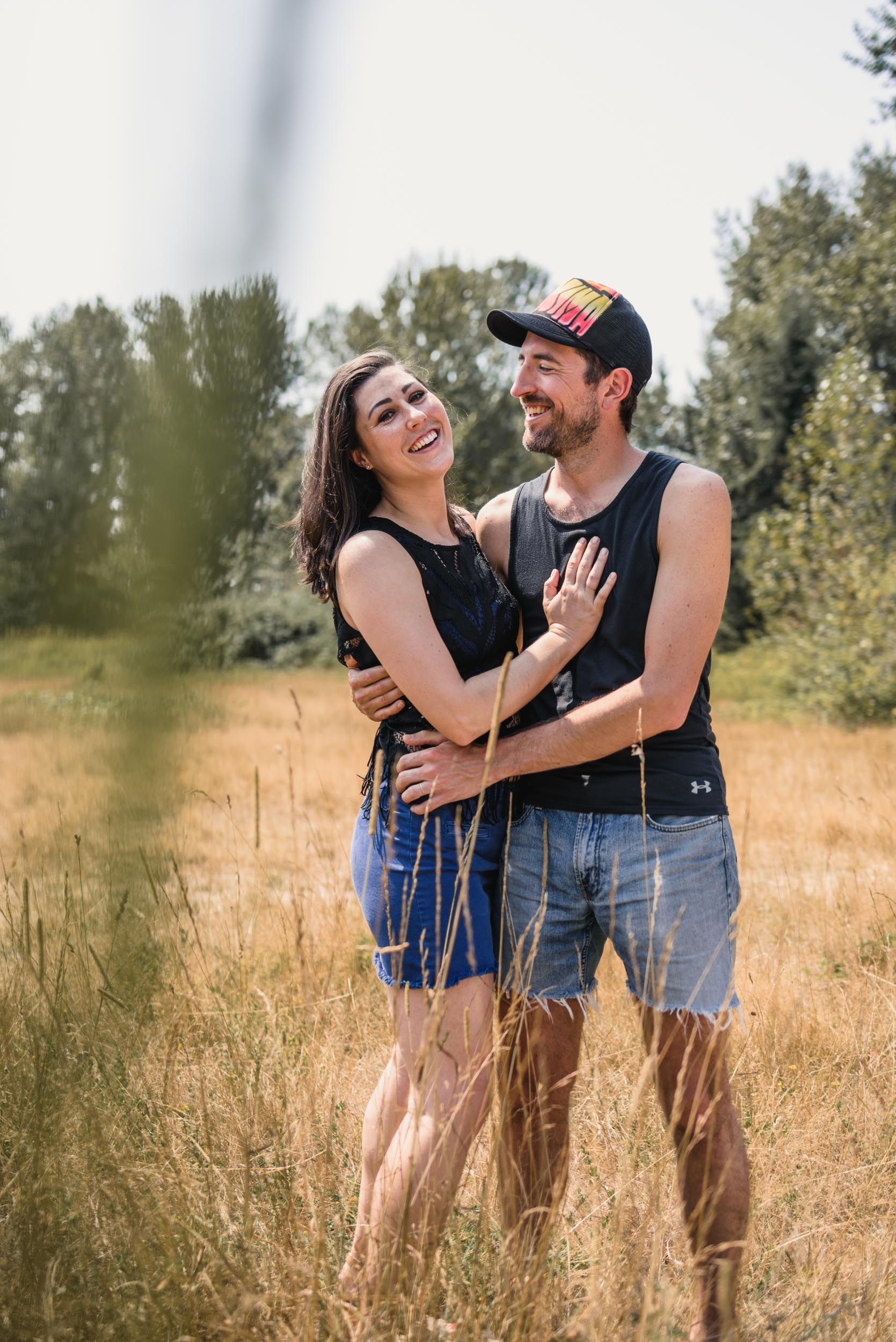 Couple hugging and smiling in field