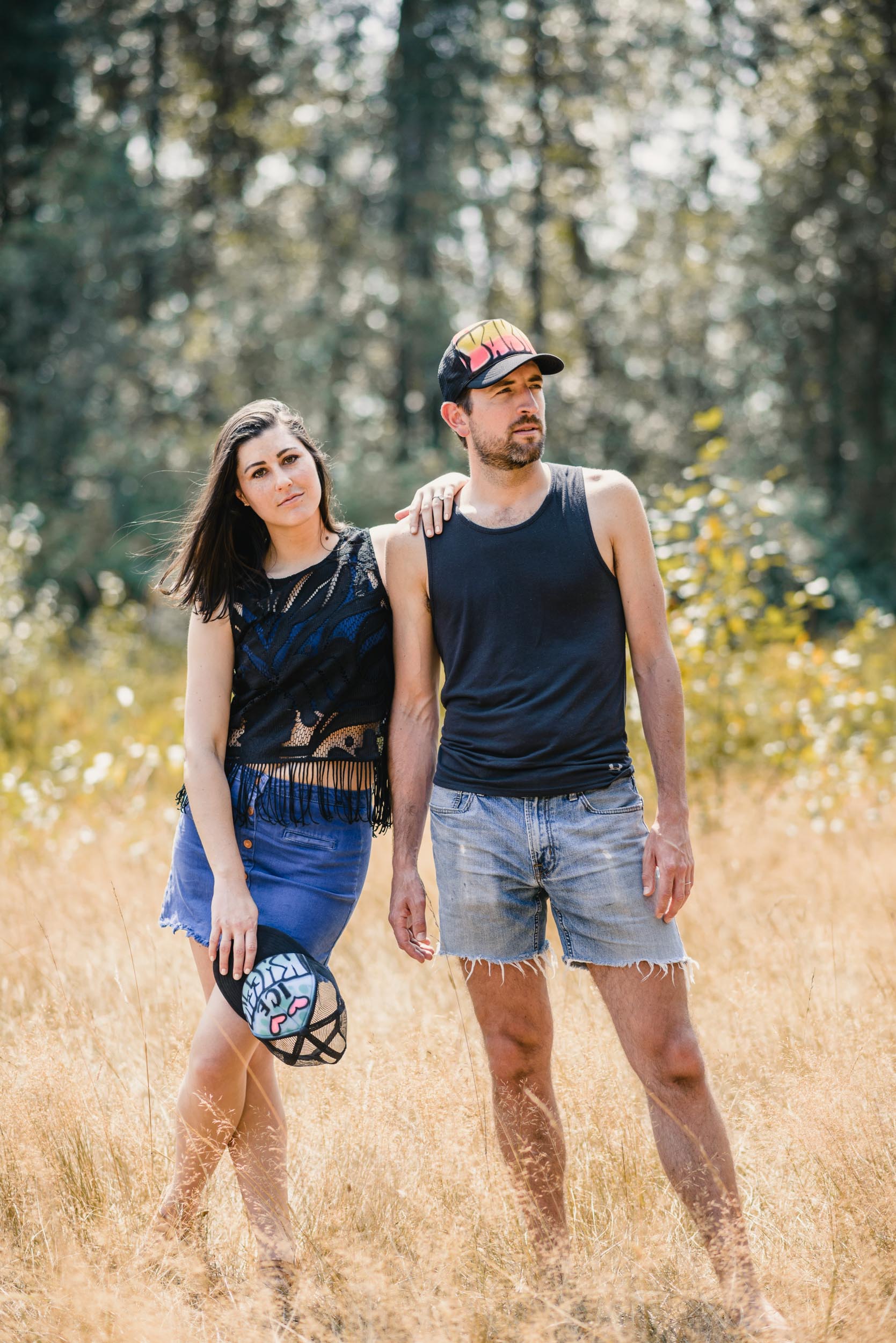 Couple standing together in tall grass field