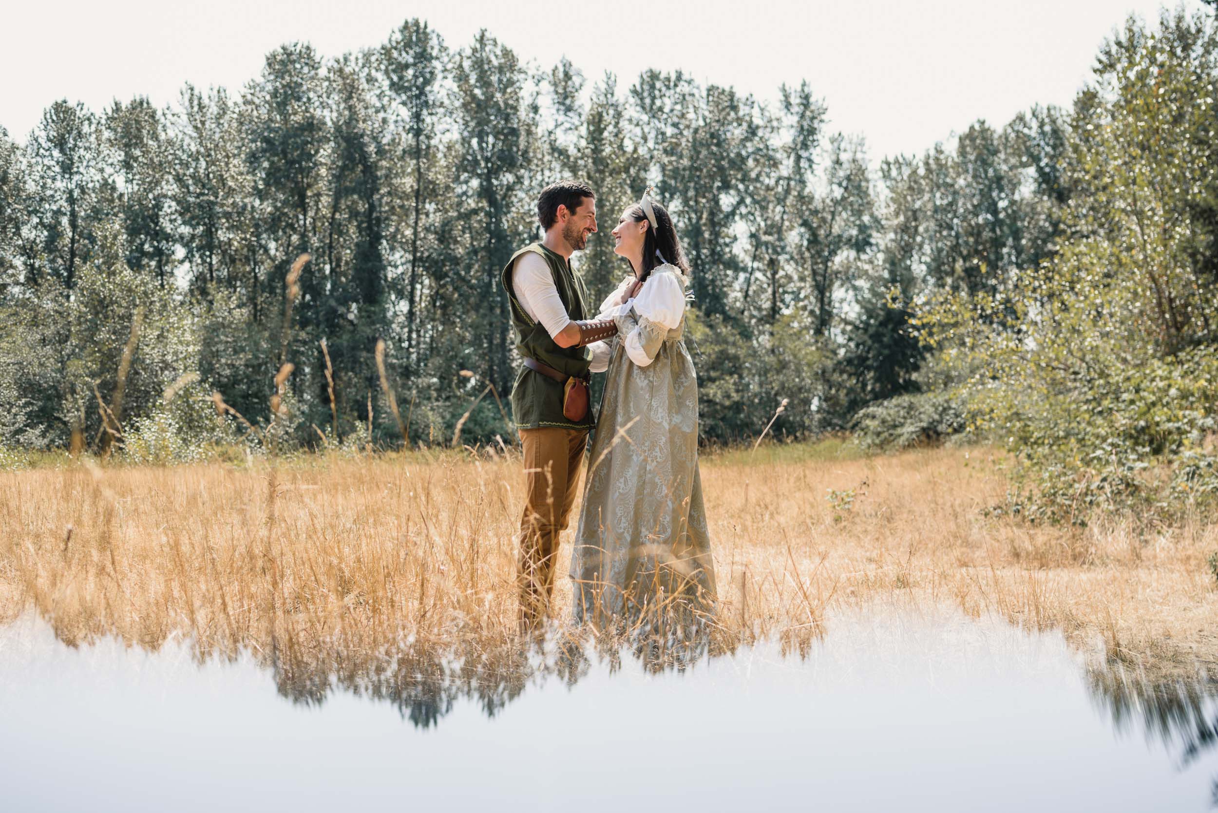 Couple facing each other in field with medieval costumes