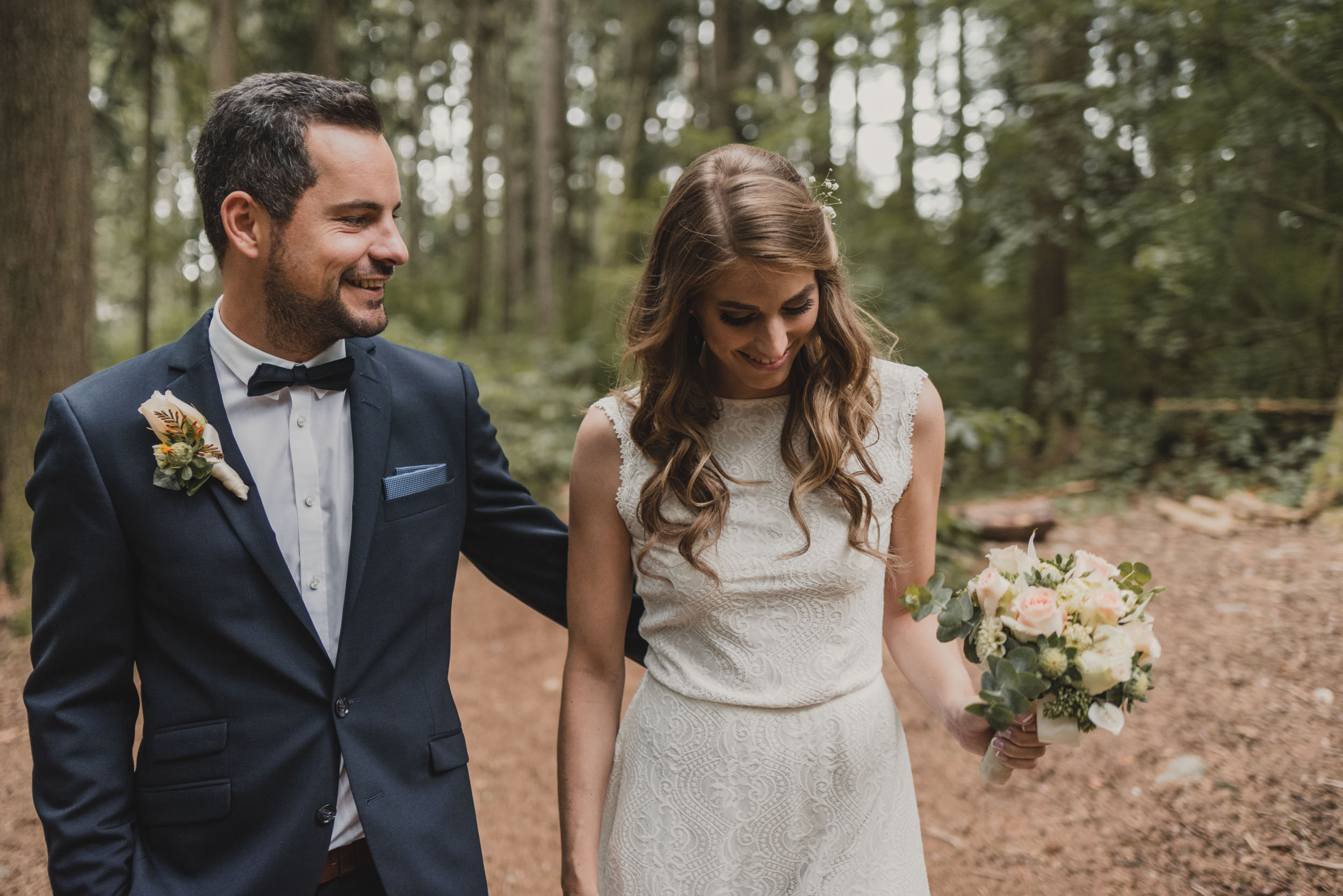 Bride and Groom walk through forest trail