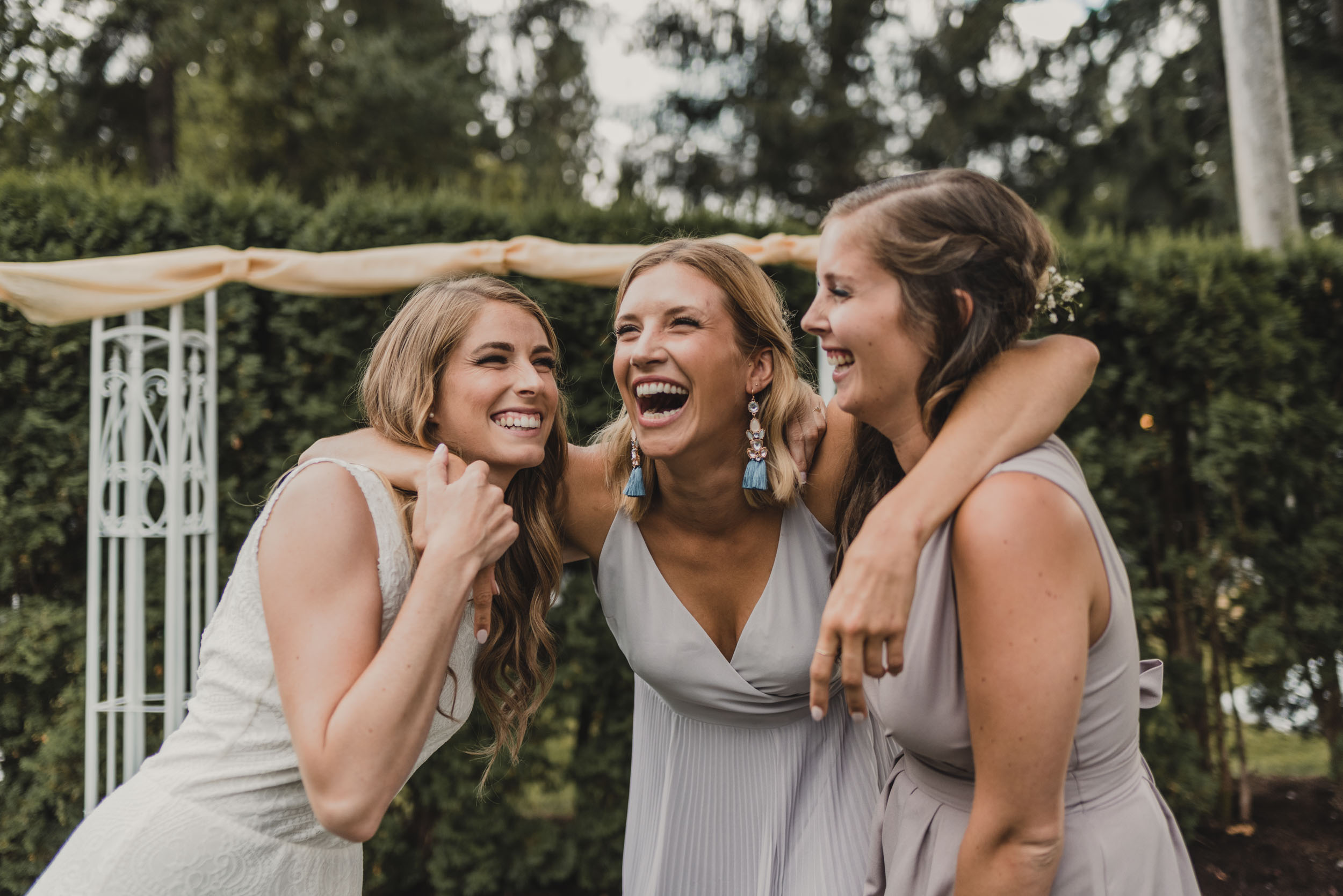 Bride laughs and embraces with friends