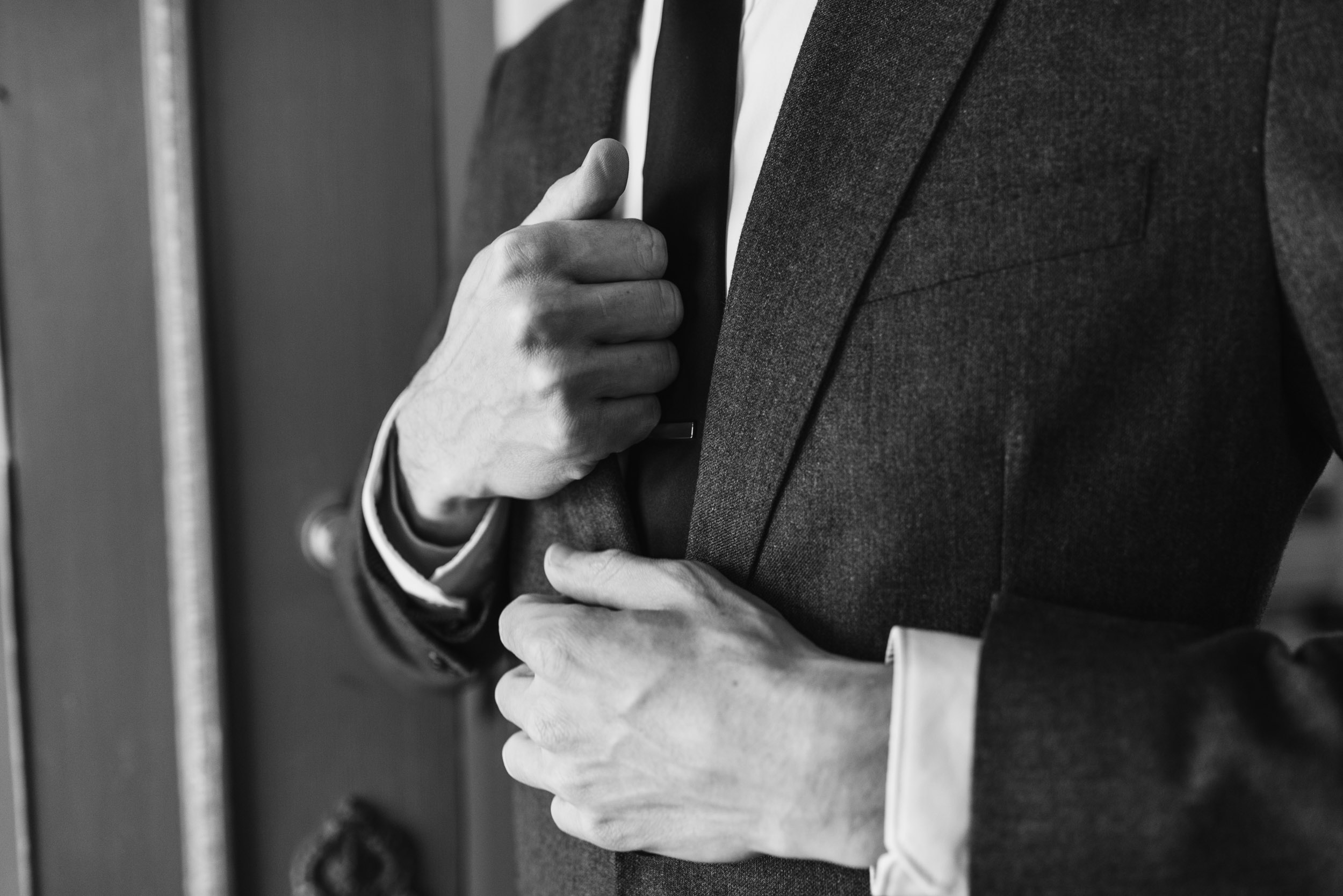 Groom putting on jacket