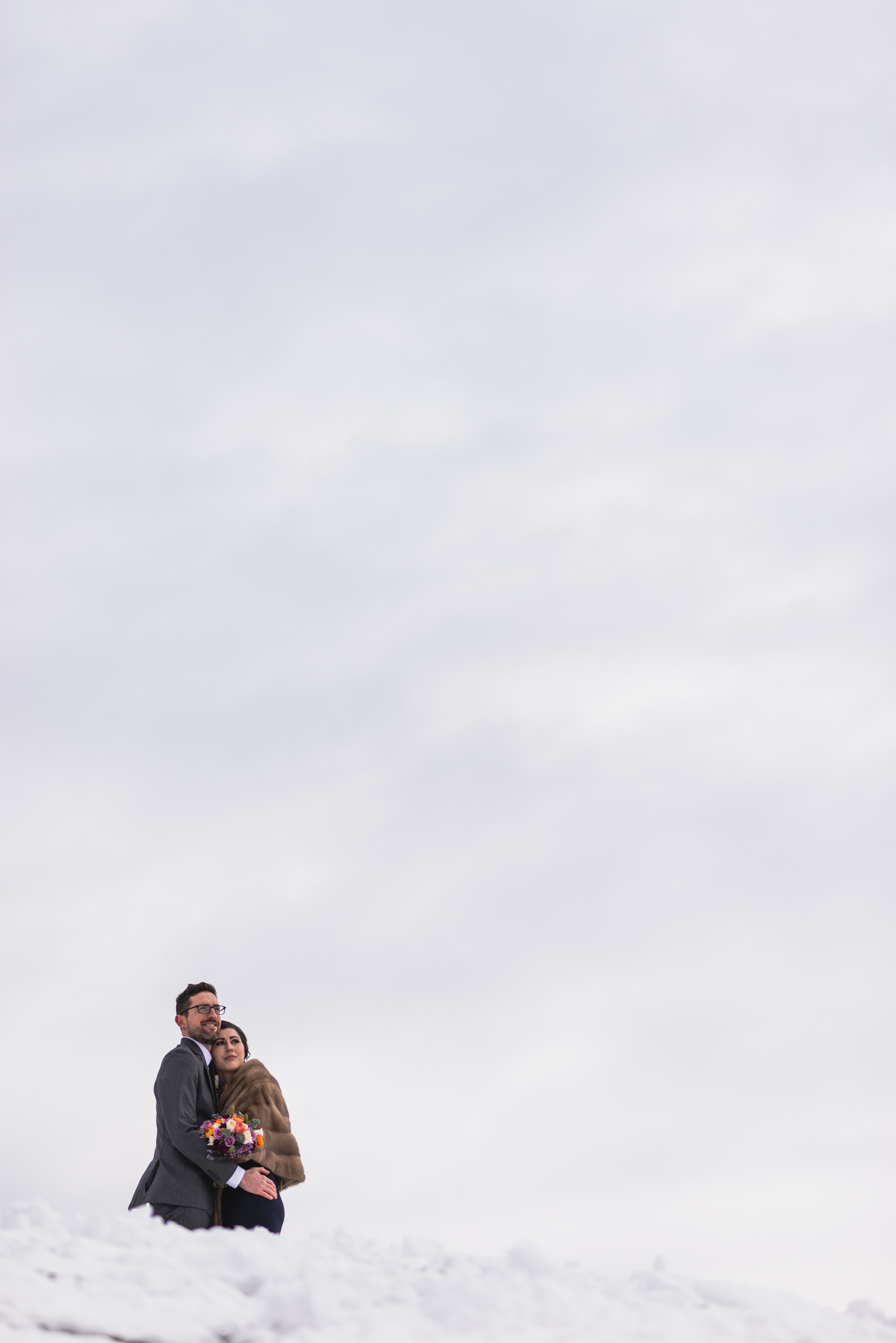 Bride and Groom embrace in snow