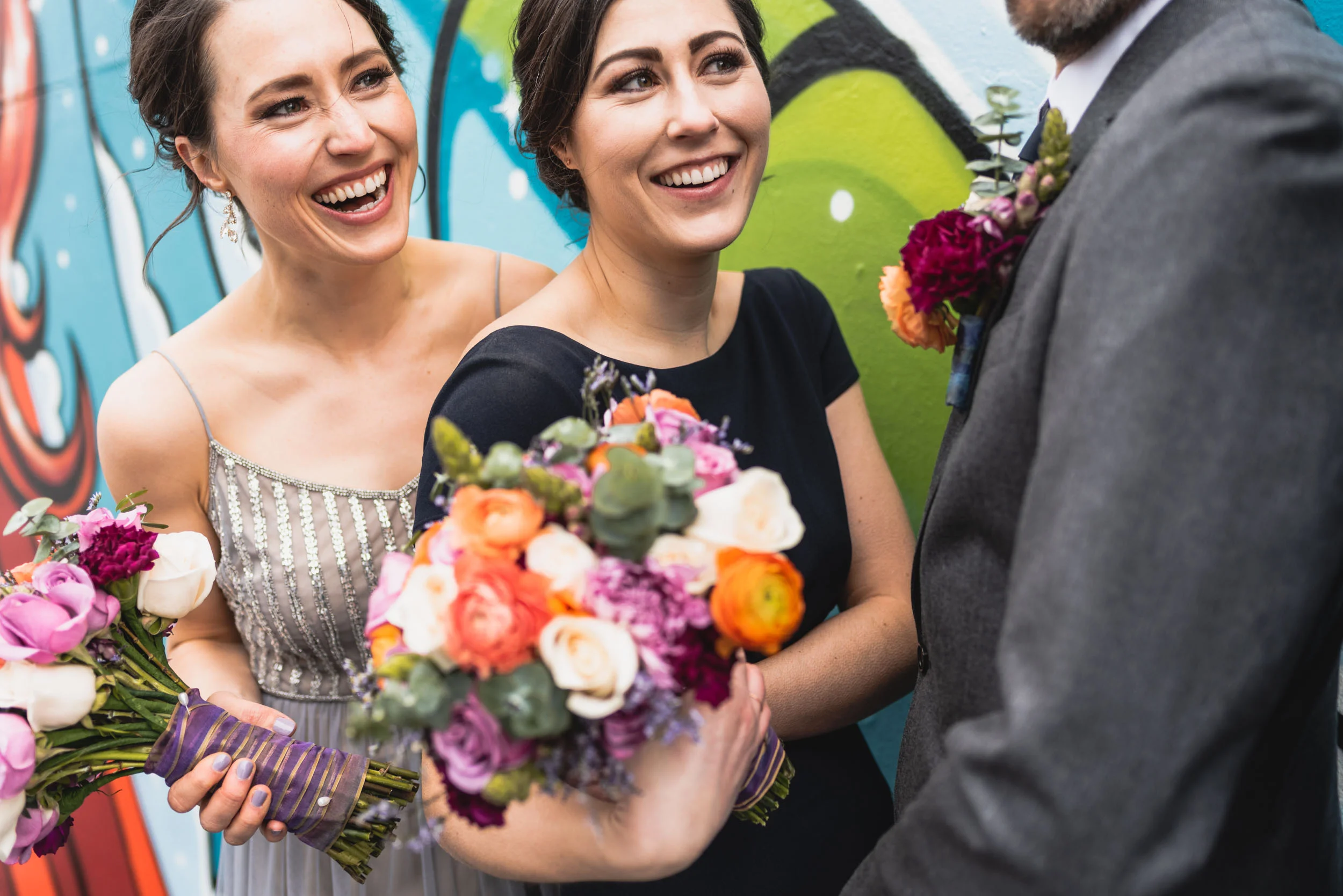 Bridal party laughs by mural