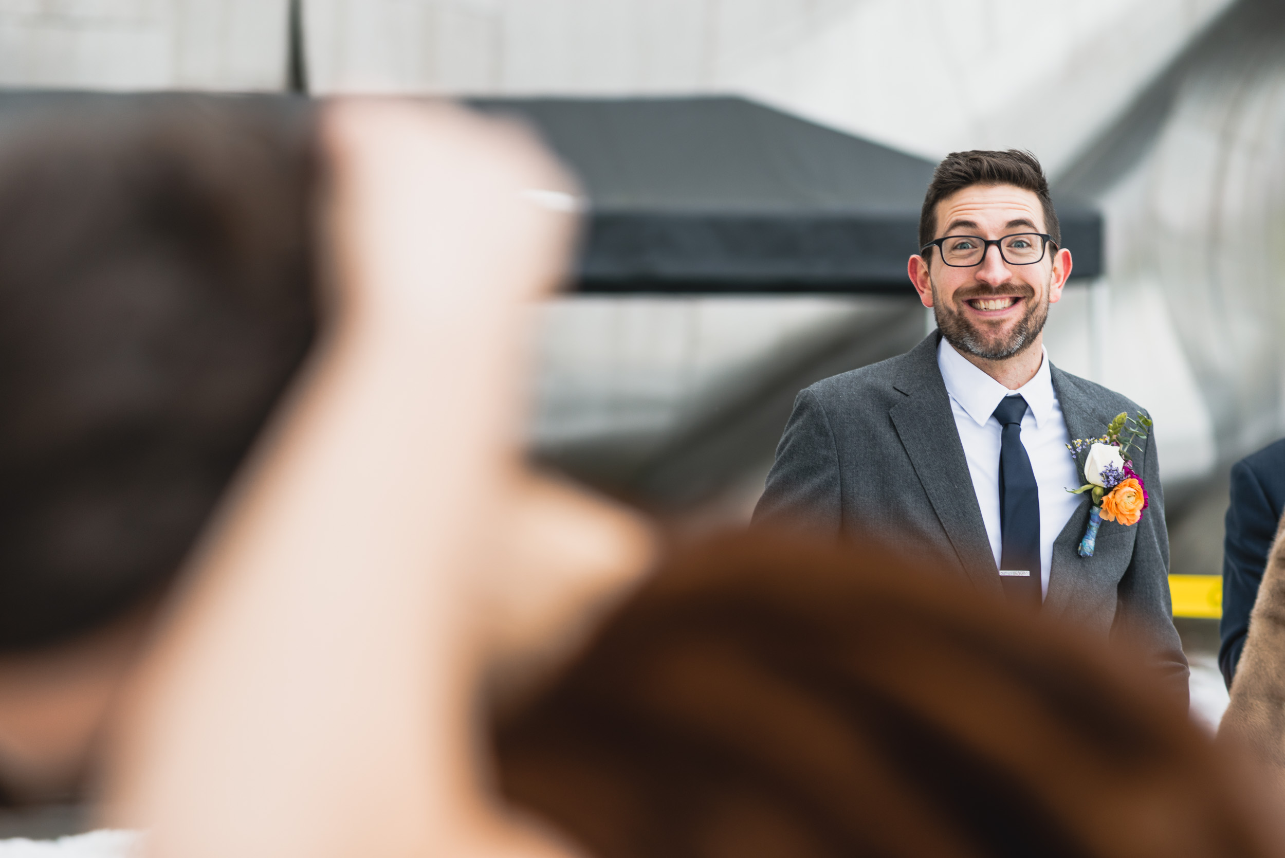 Groom happily watches Bride fix her hair