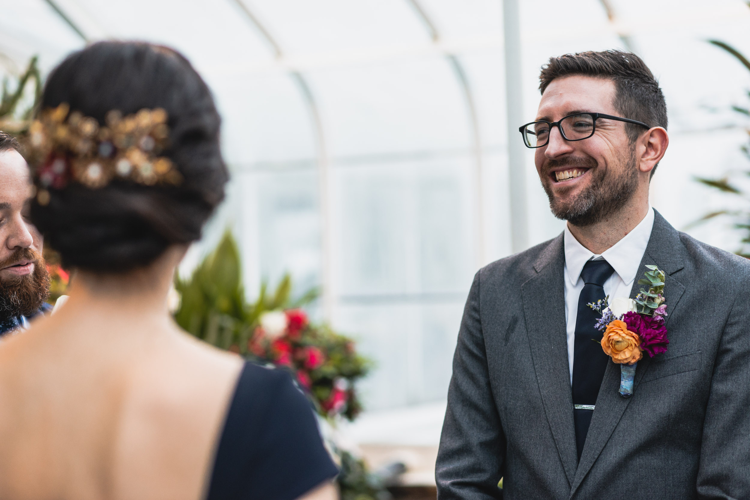 Groom smiles at Bride in conservatory