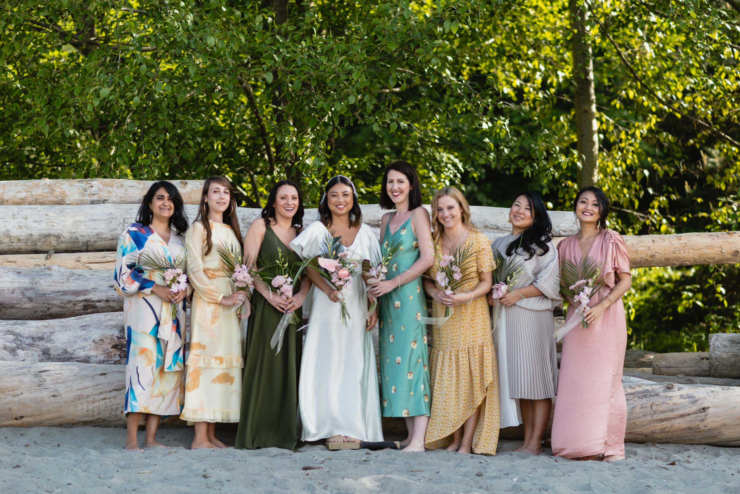 Bride and bridesmaids at beach with logs