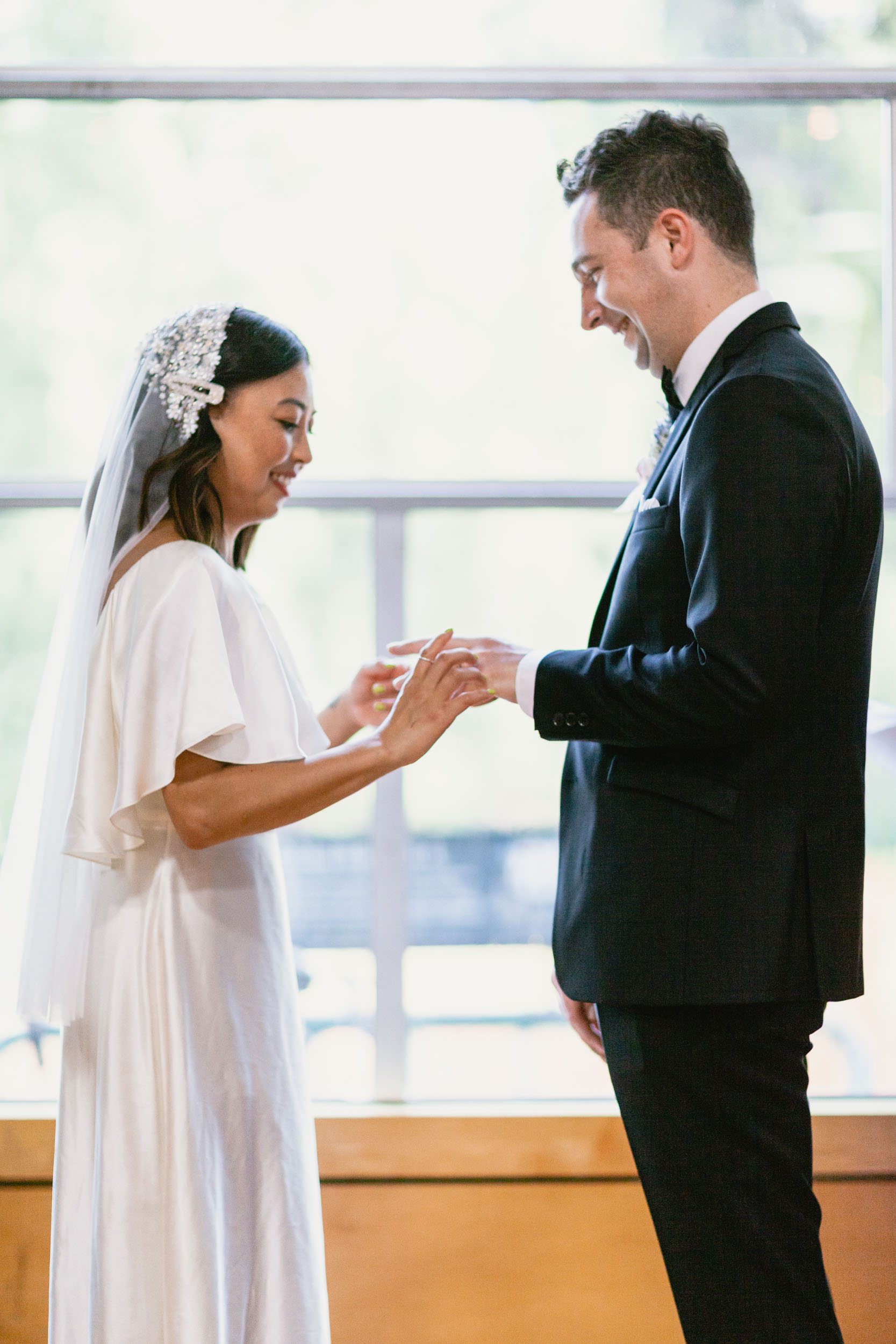 Bride putting ring on Groom's finger
