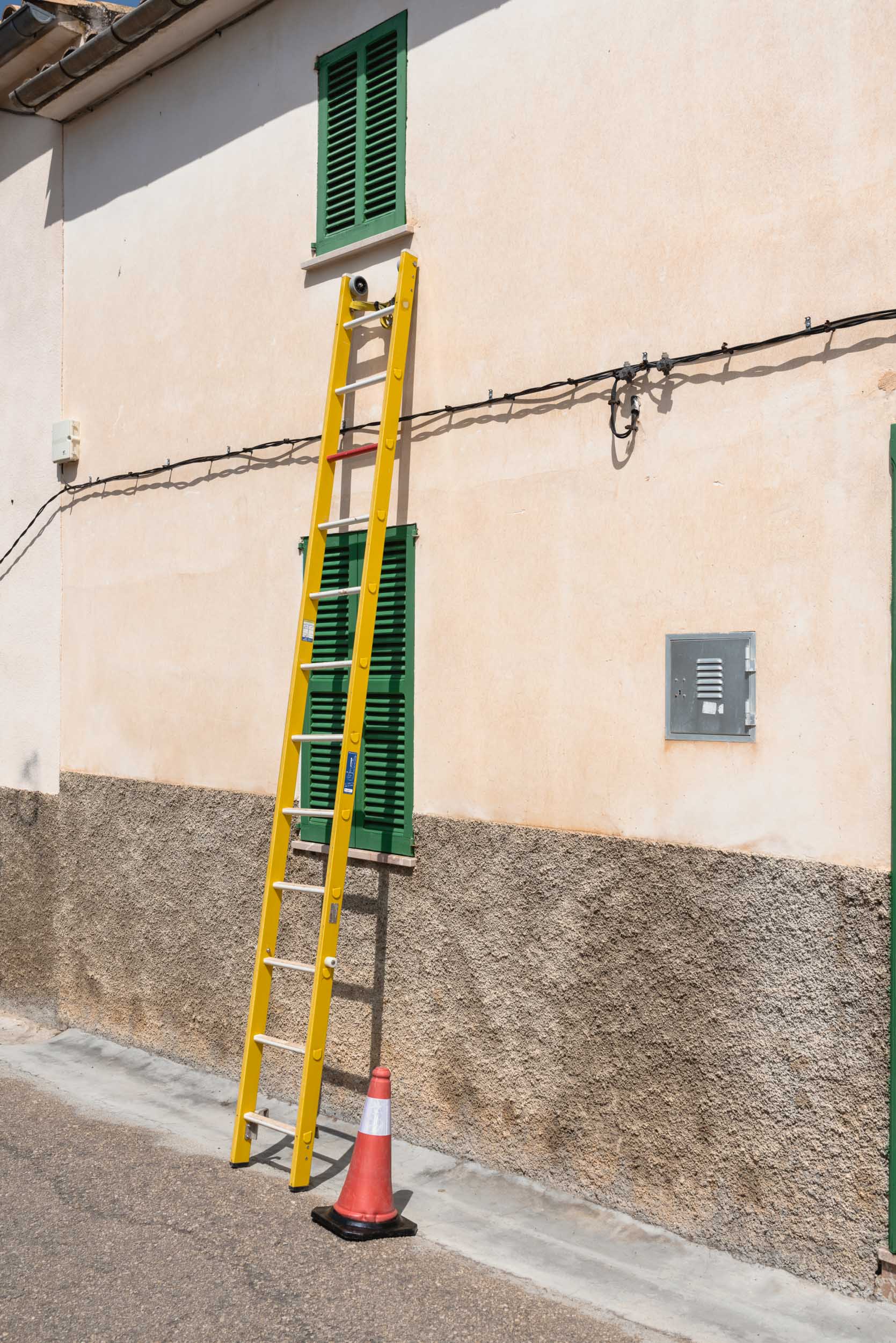 Yellow ladder on building in Sineu, Spain