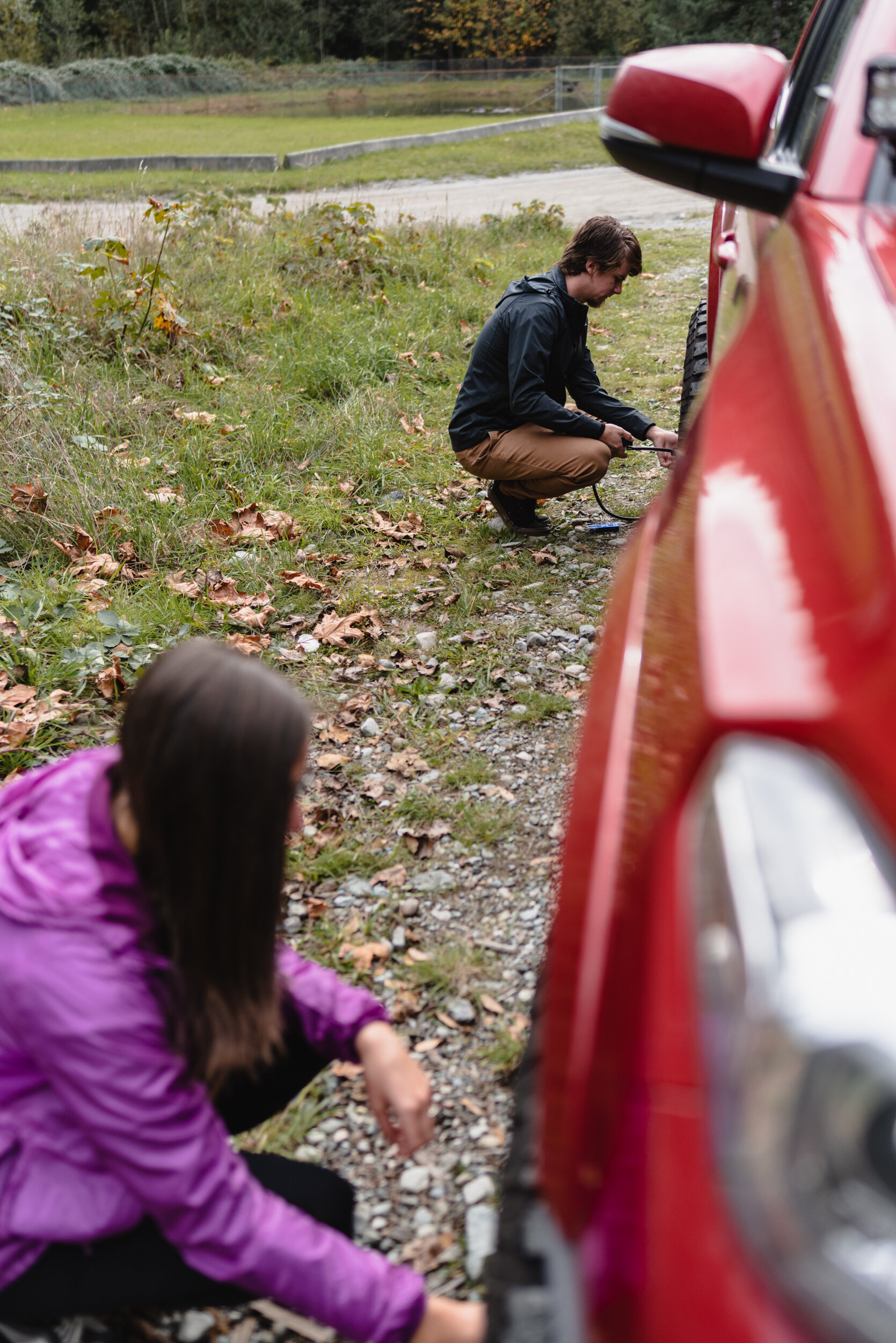 Couple inflating tires on car