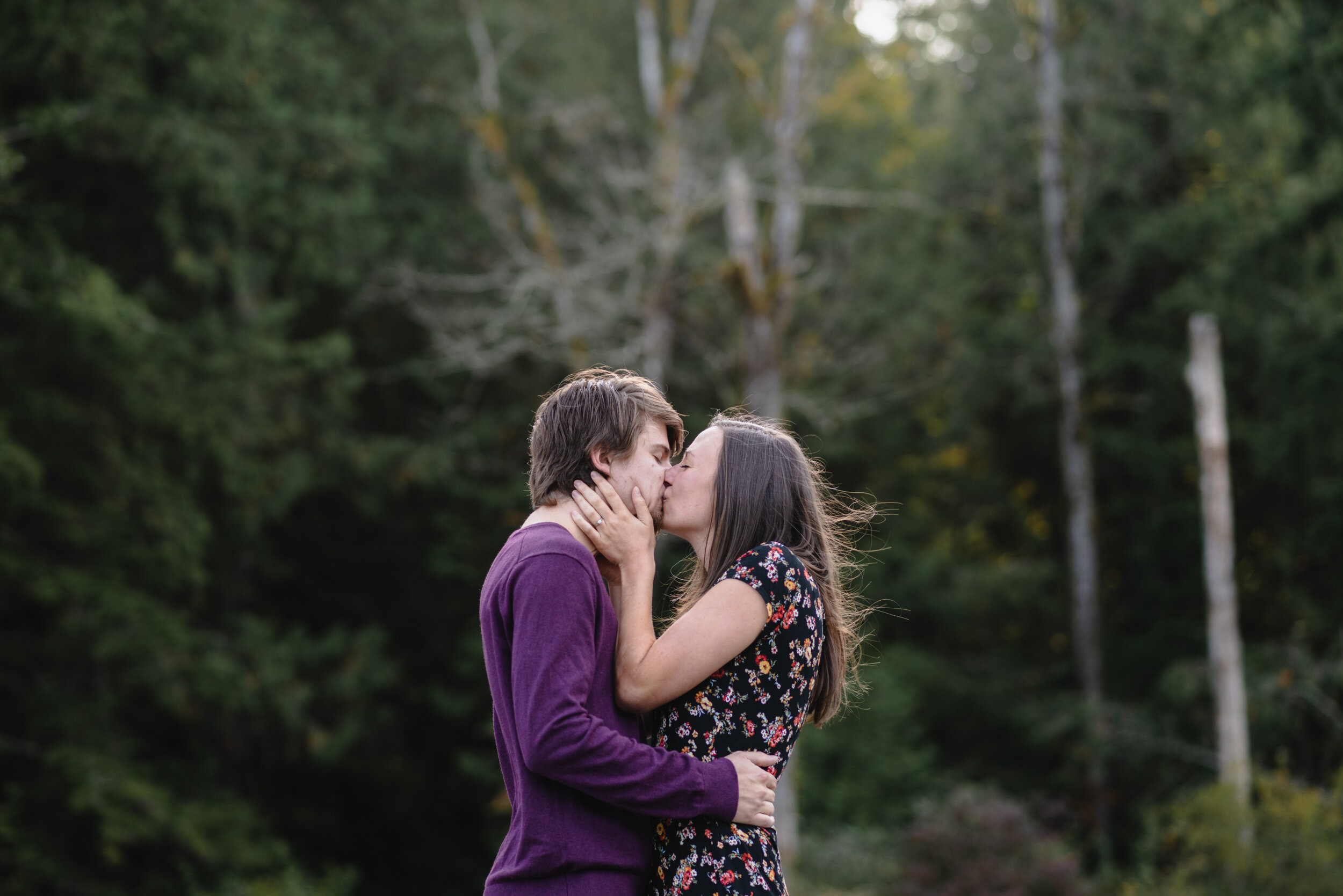 Couple kissing with tress behind them