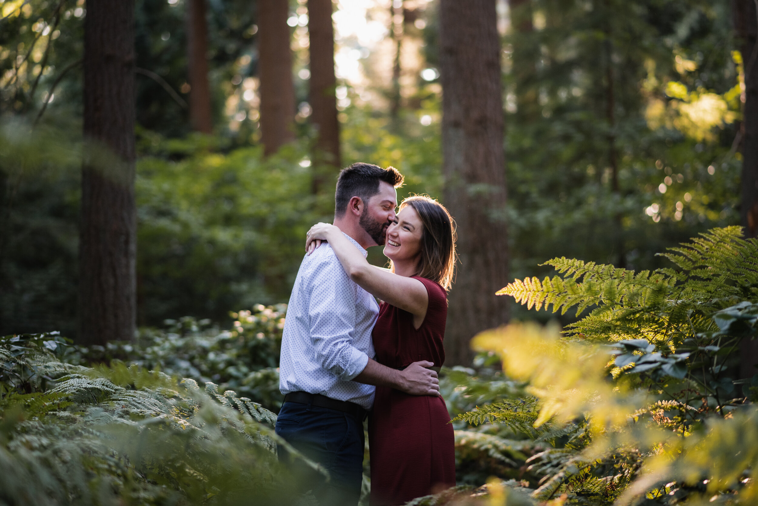 Couple in ferns kissing backlit