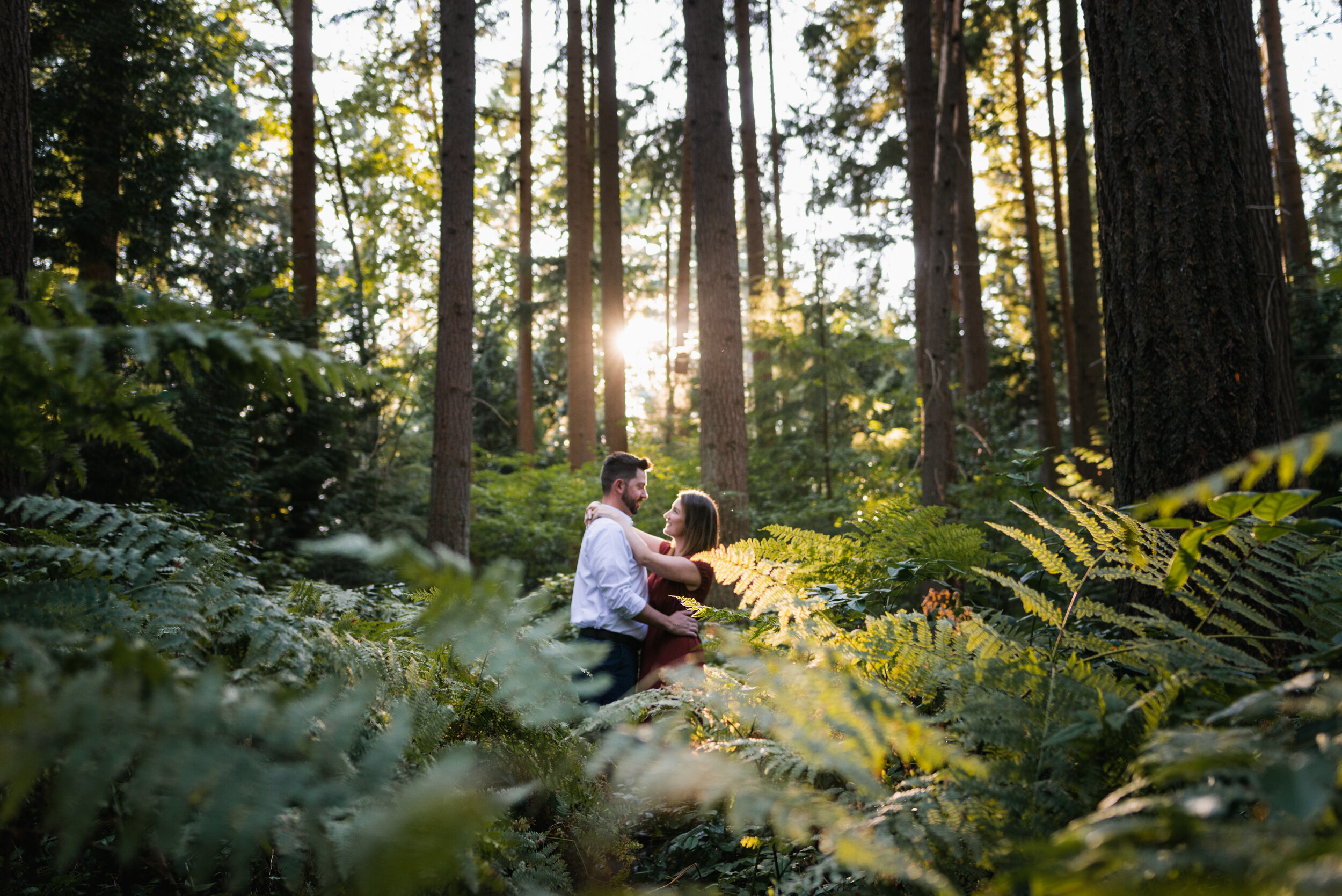 Couple in ferns kissing backlit