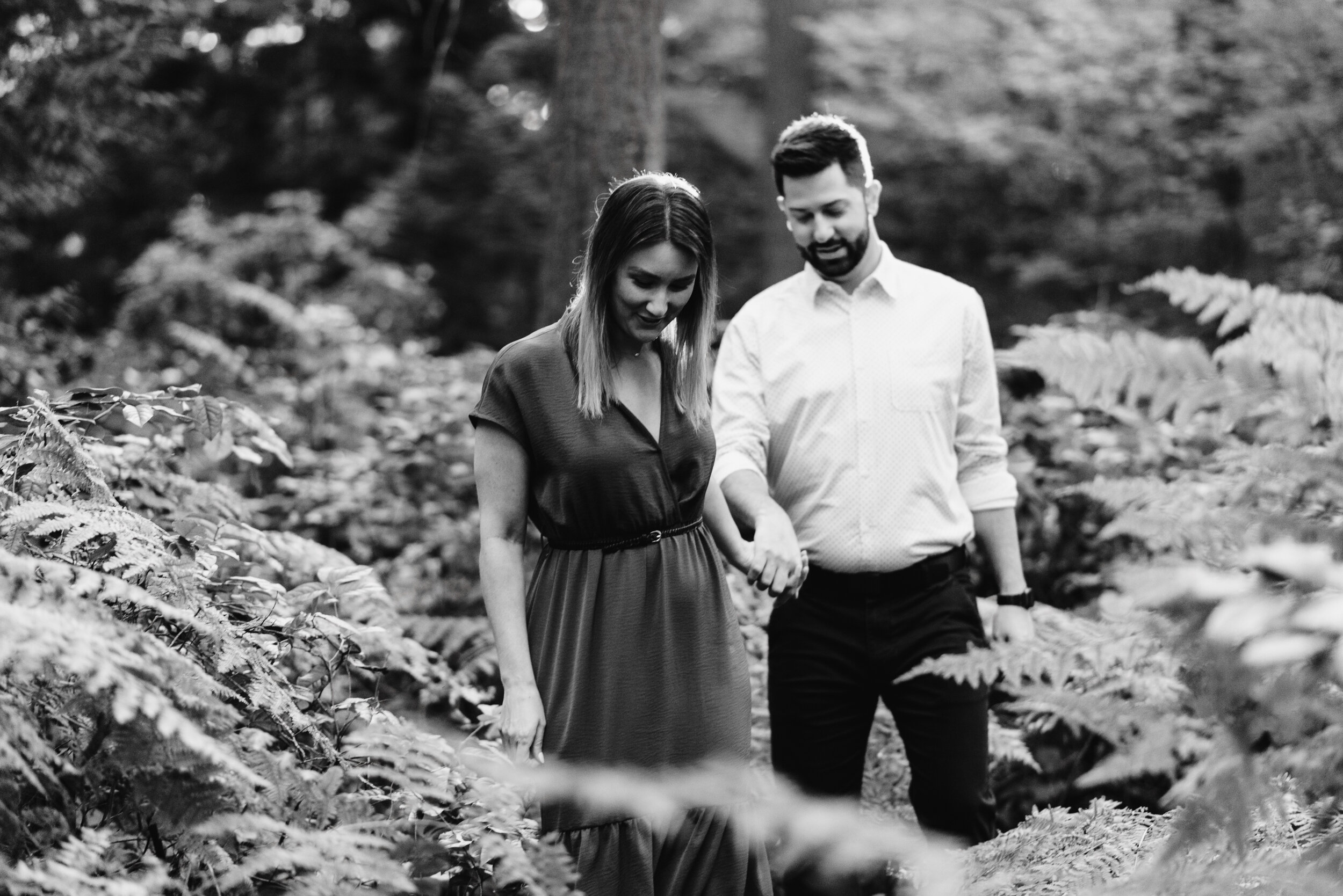 Couple walking through ferns black and white