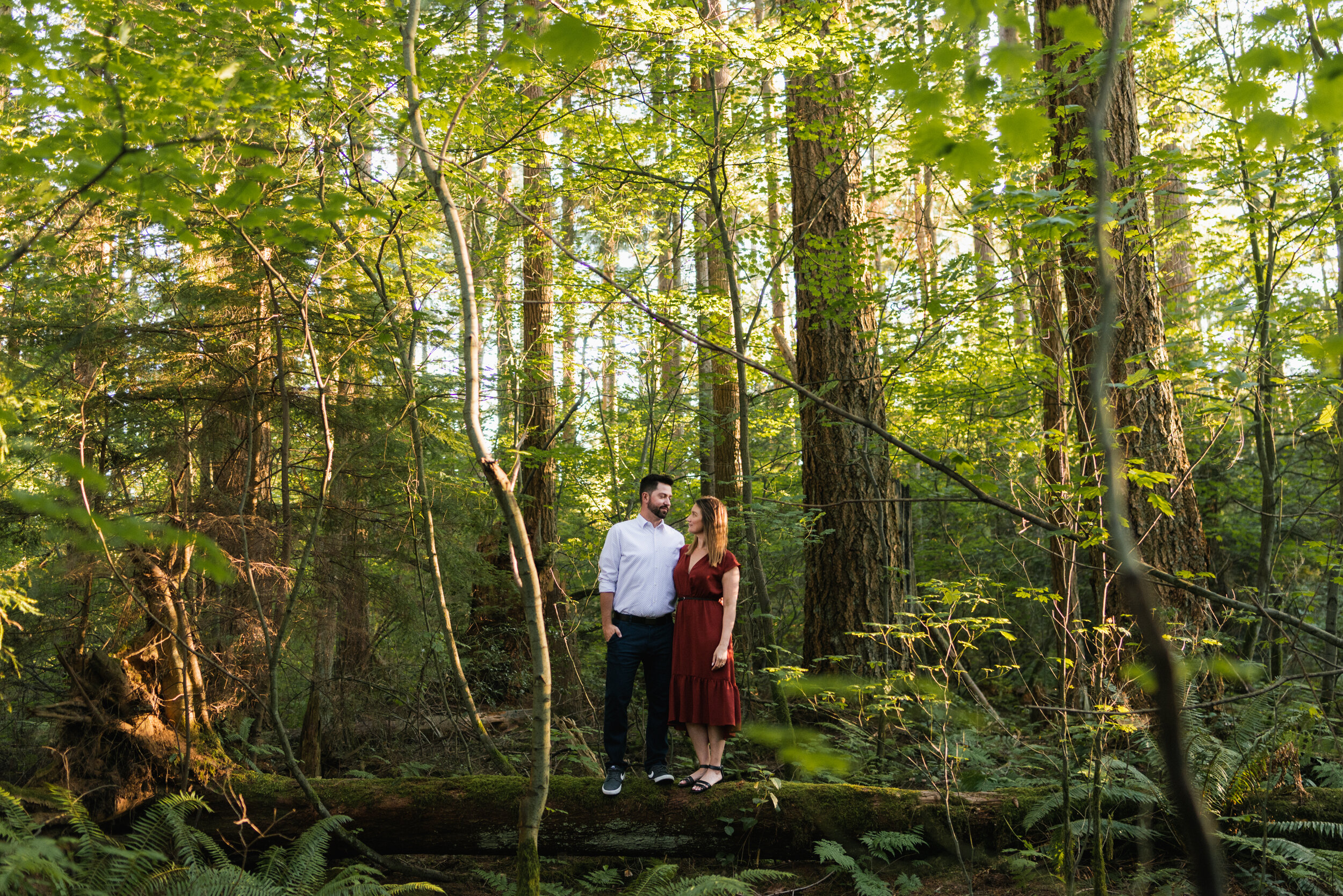 Couple standing in lush green forest