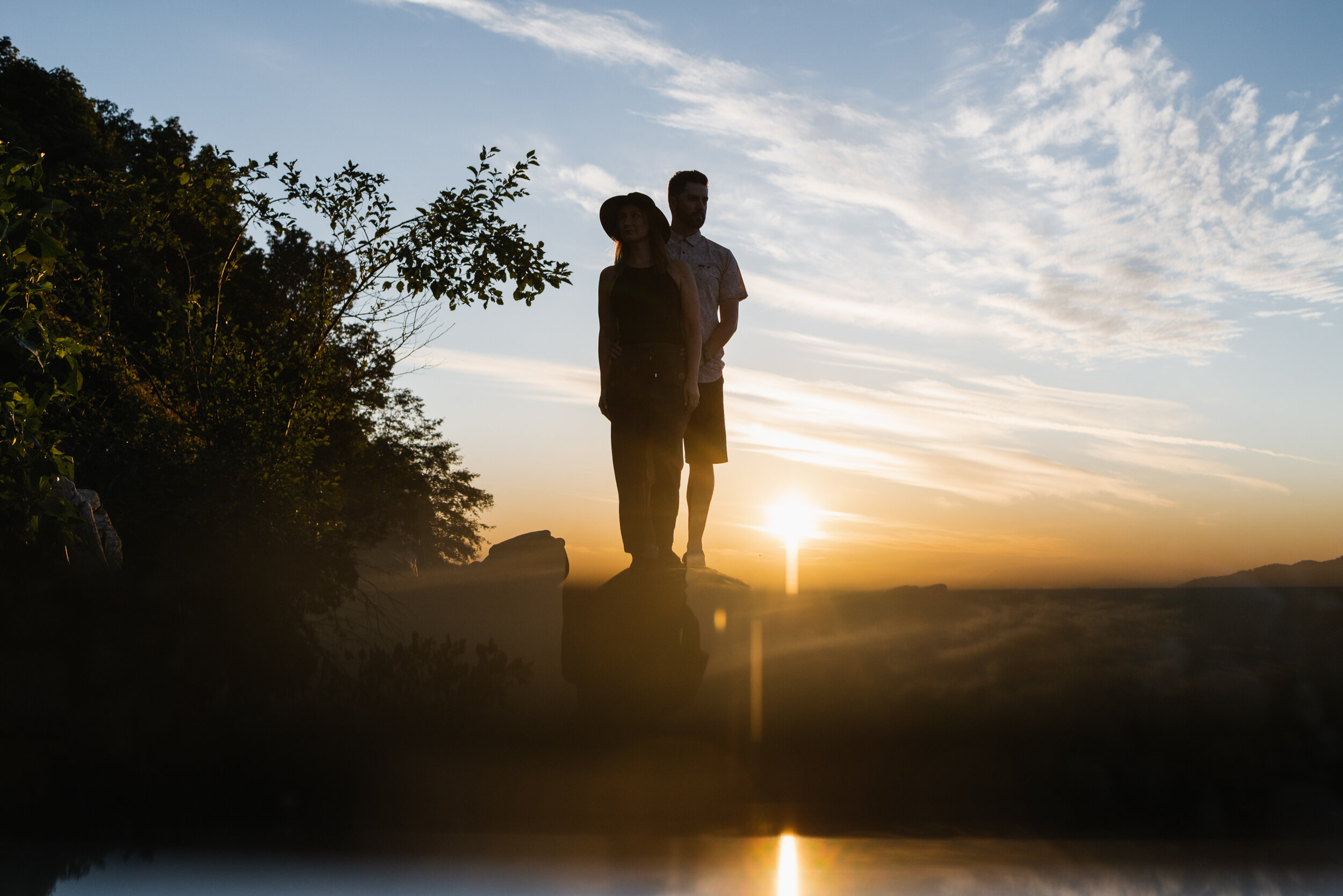 Backlit silhouette couple on log Acadia Beach reflection