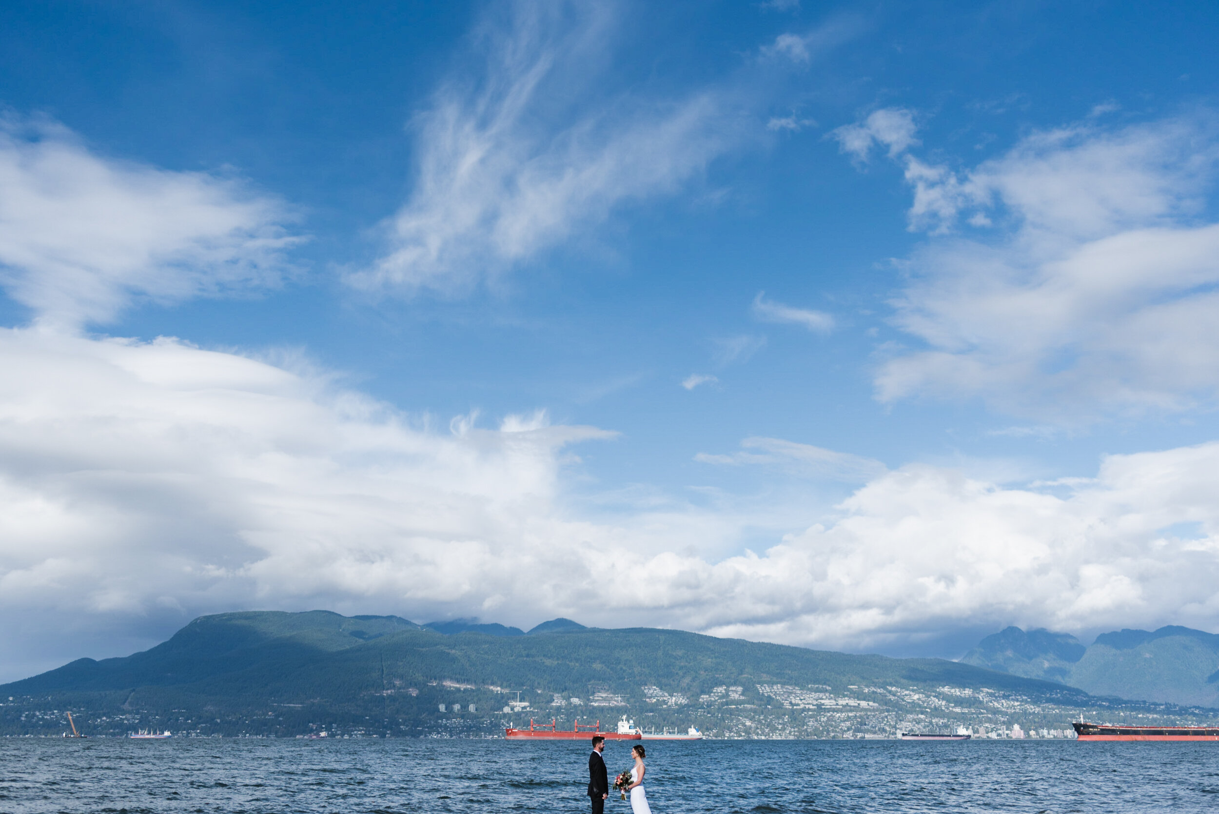 Couple standing at beach with mountains