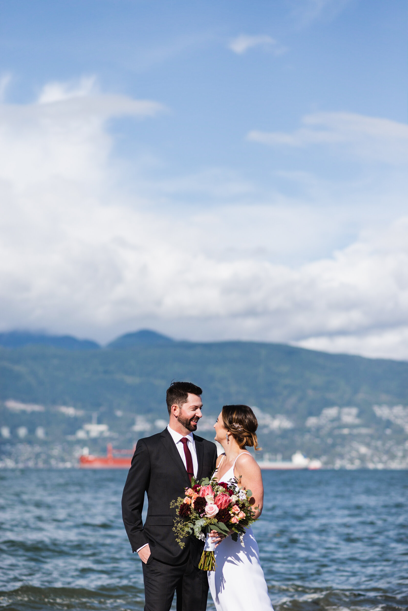 Couple standing at beach with mountains