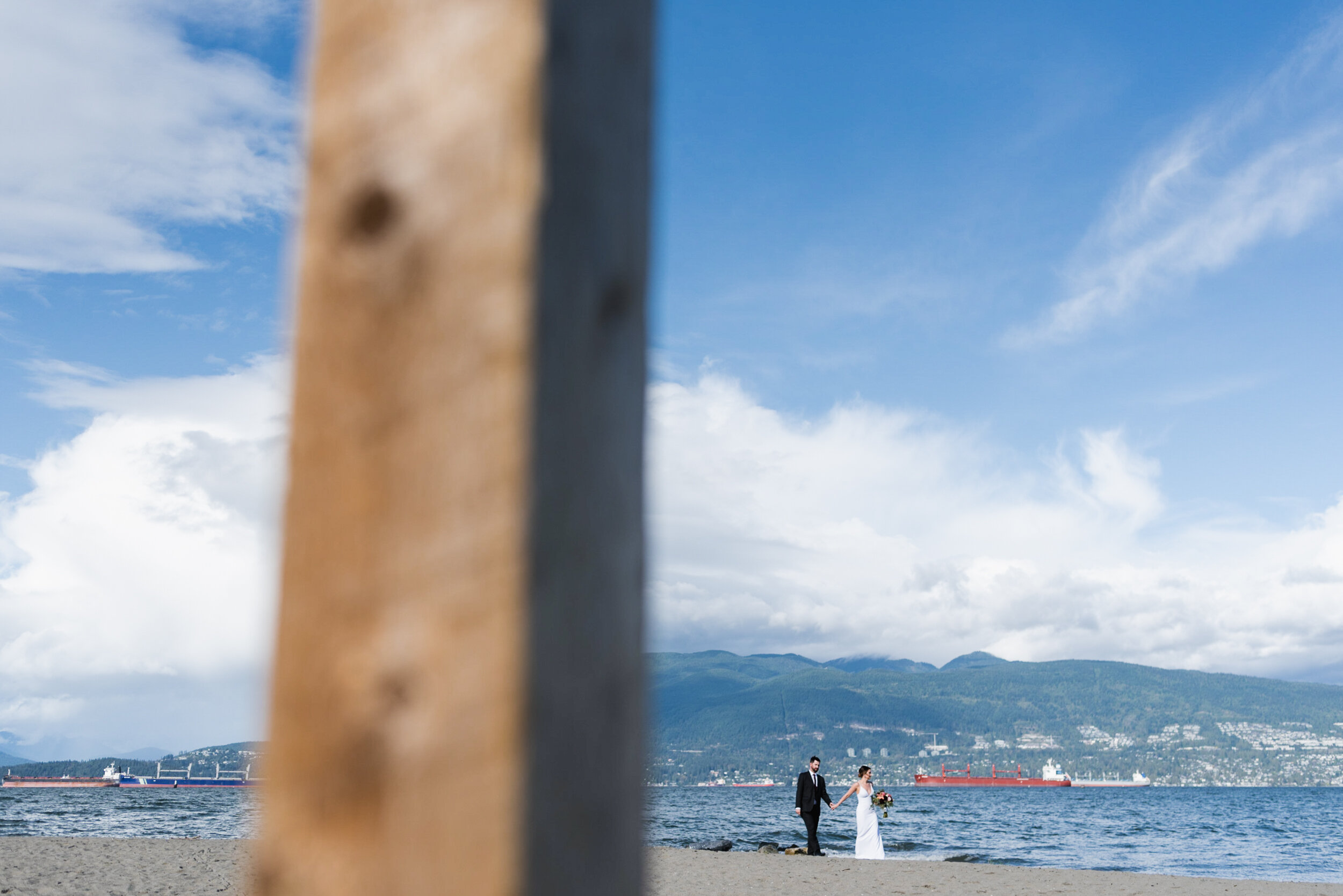 Couple standing at beach with mountains