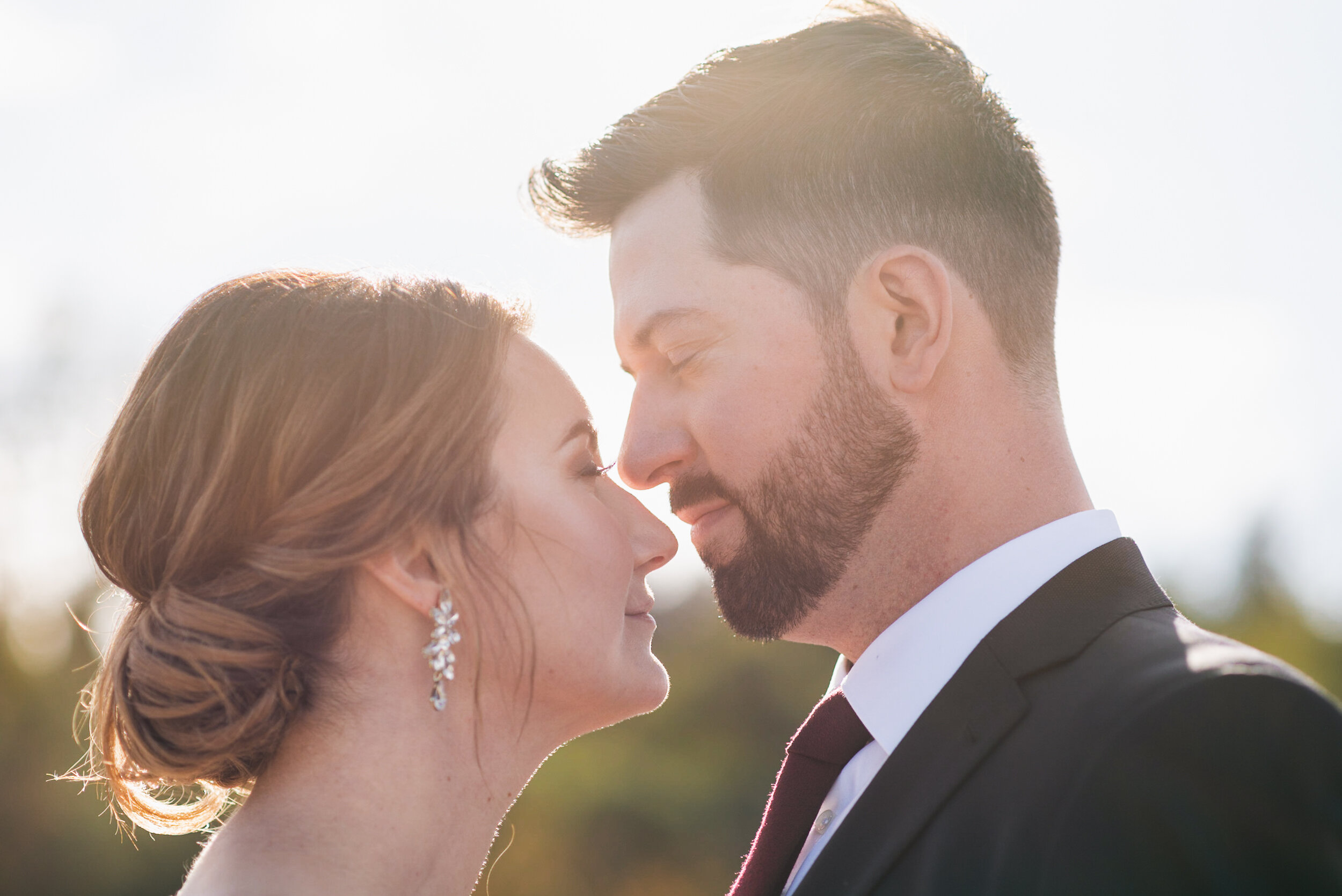 Couple touching noses backlit