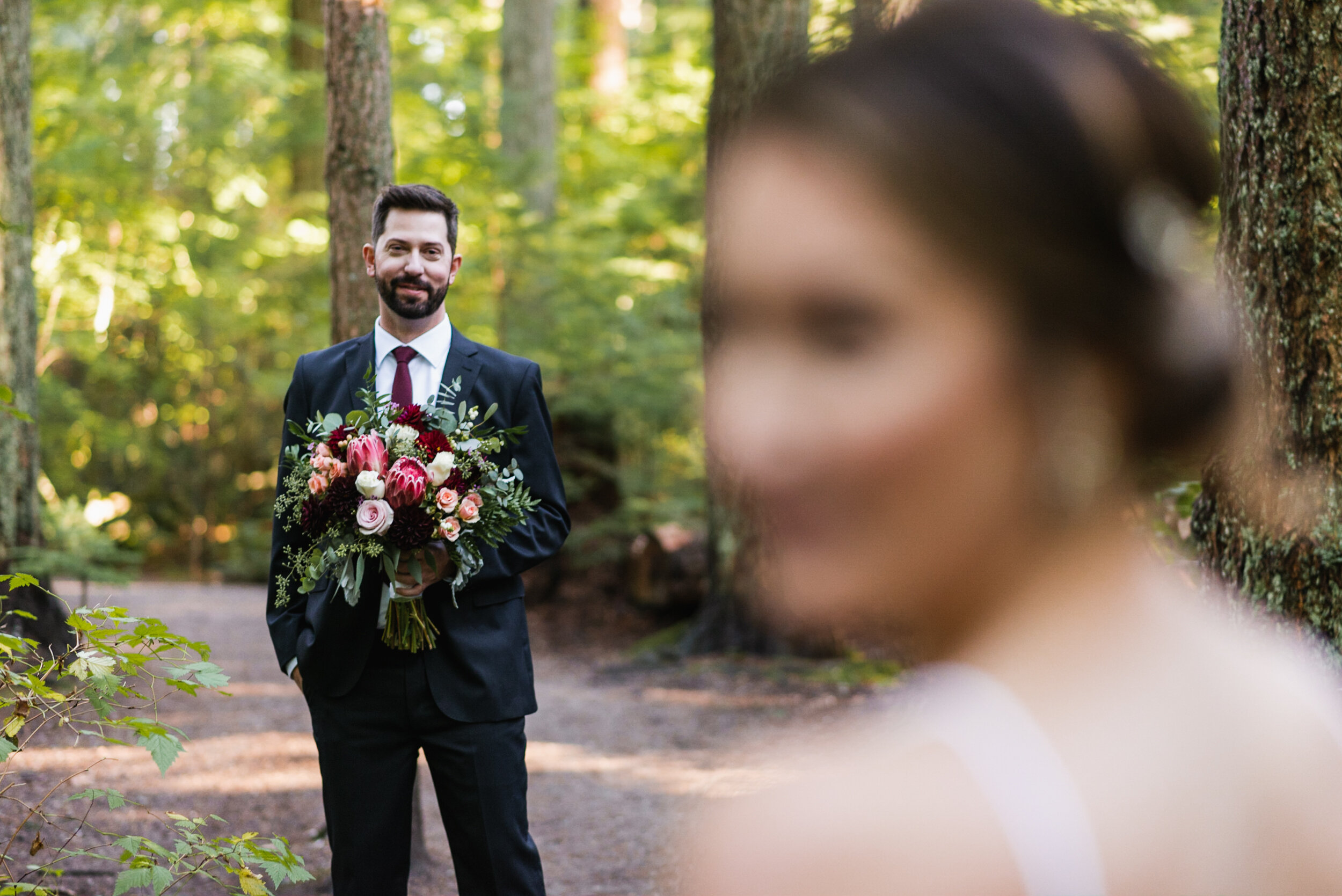 Groom looks at Bride in the forest
