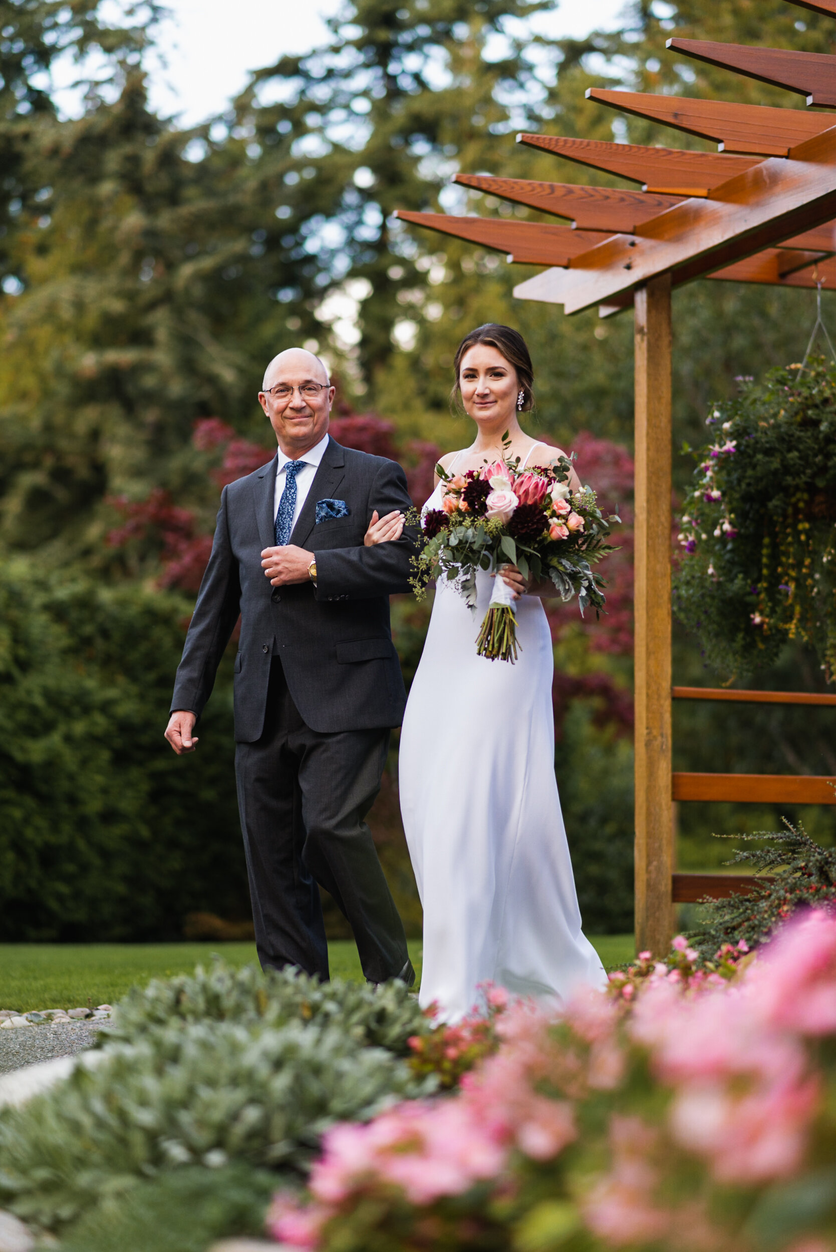Bride walks down path with Father