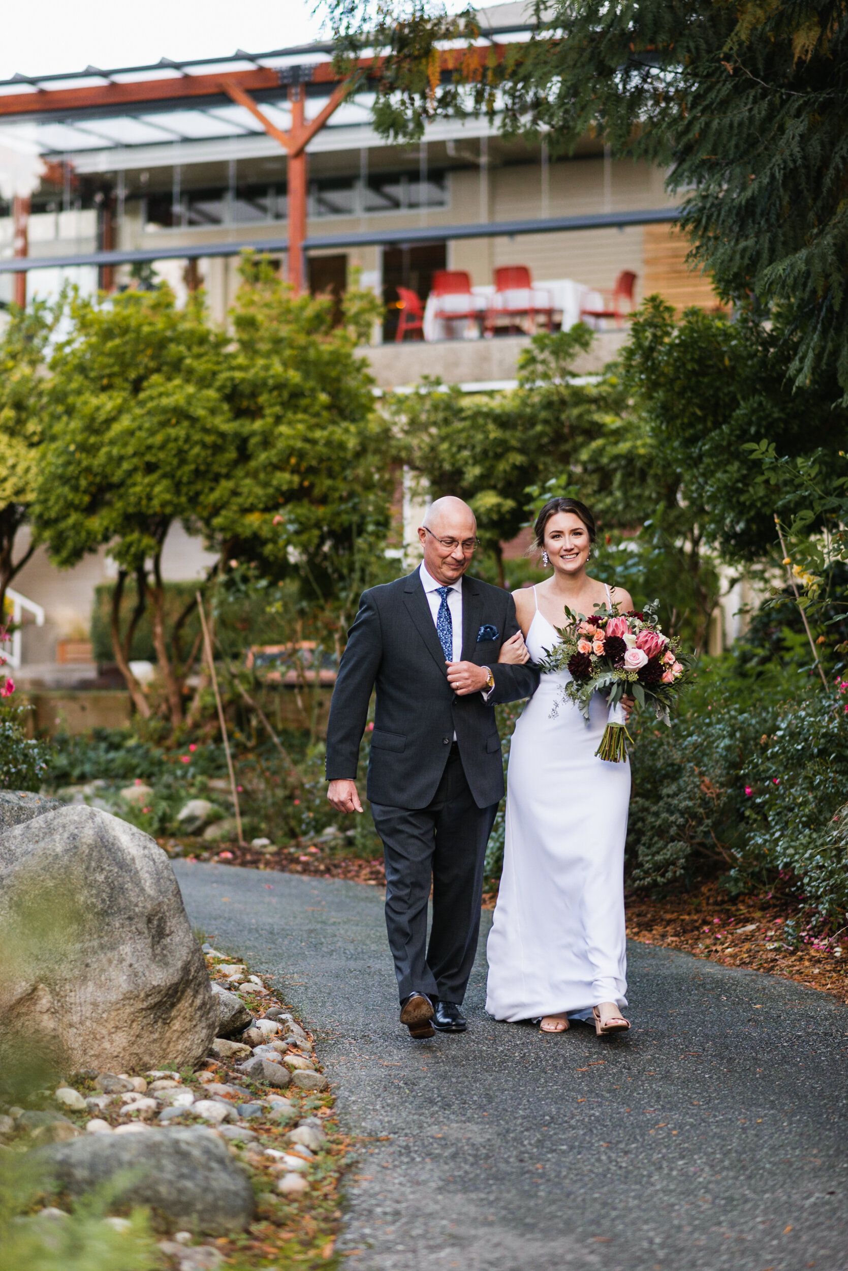 Bride walks down path with Father