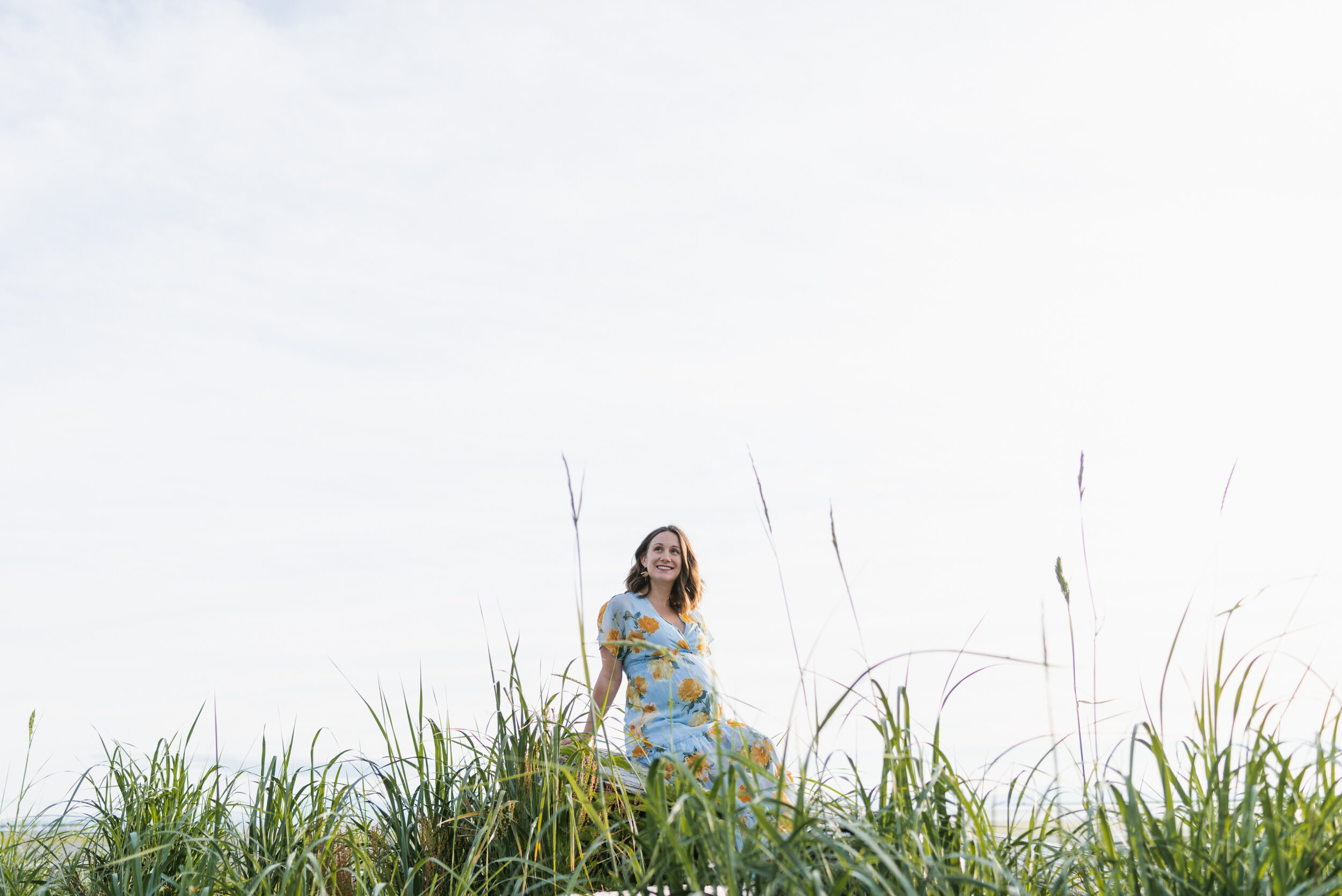 Pregnant woman beach grass sitting