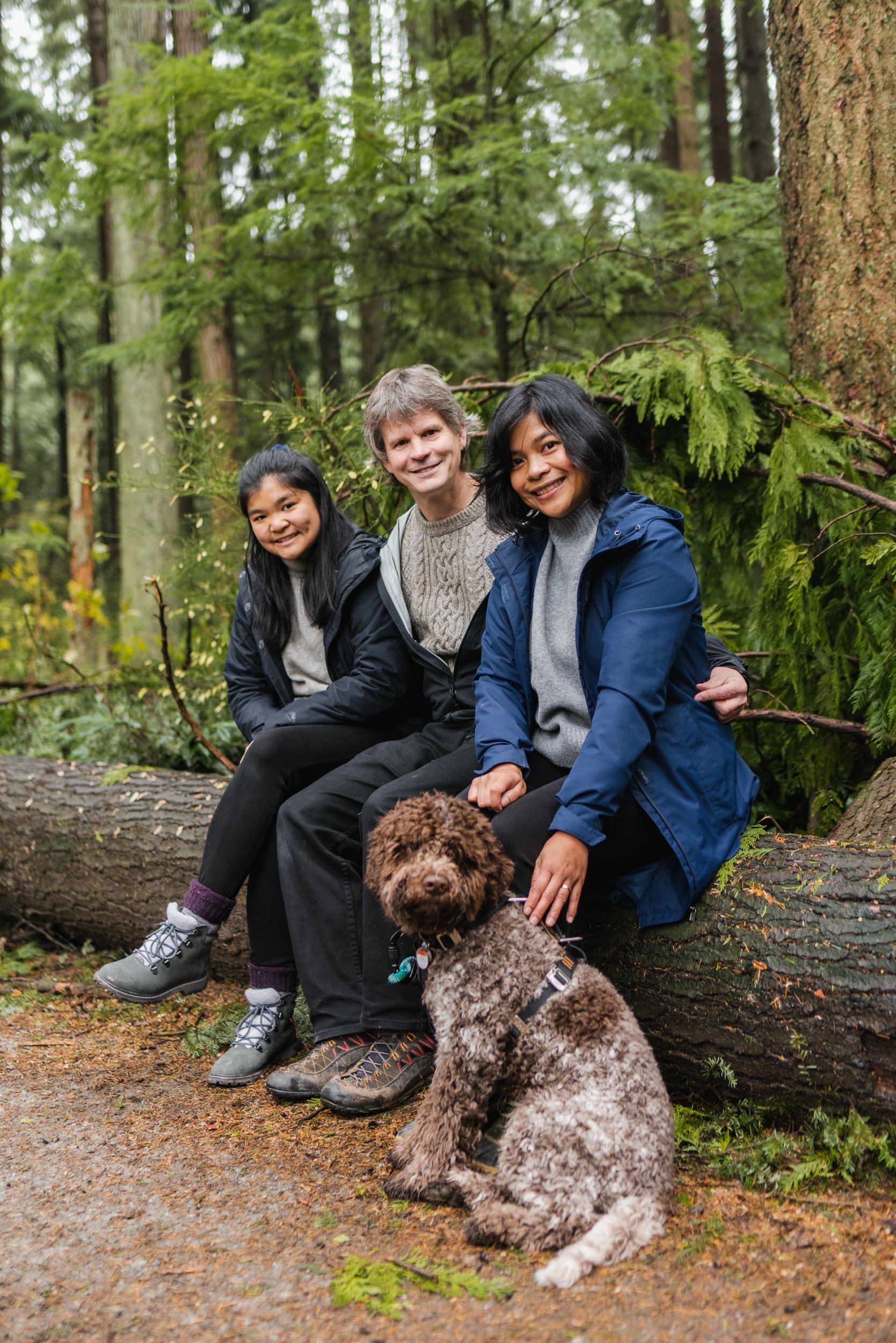 Family sitting on log with dog