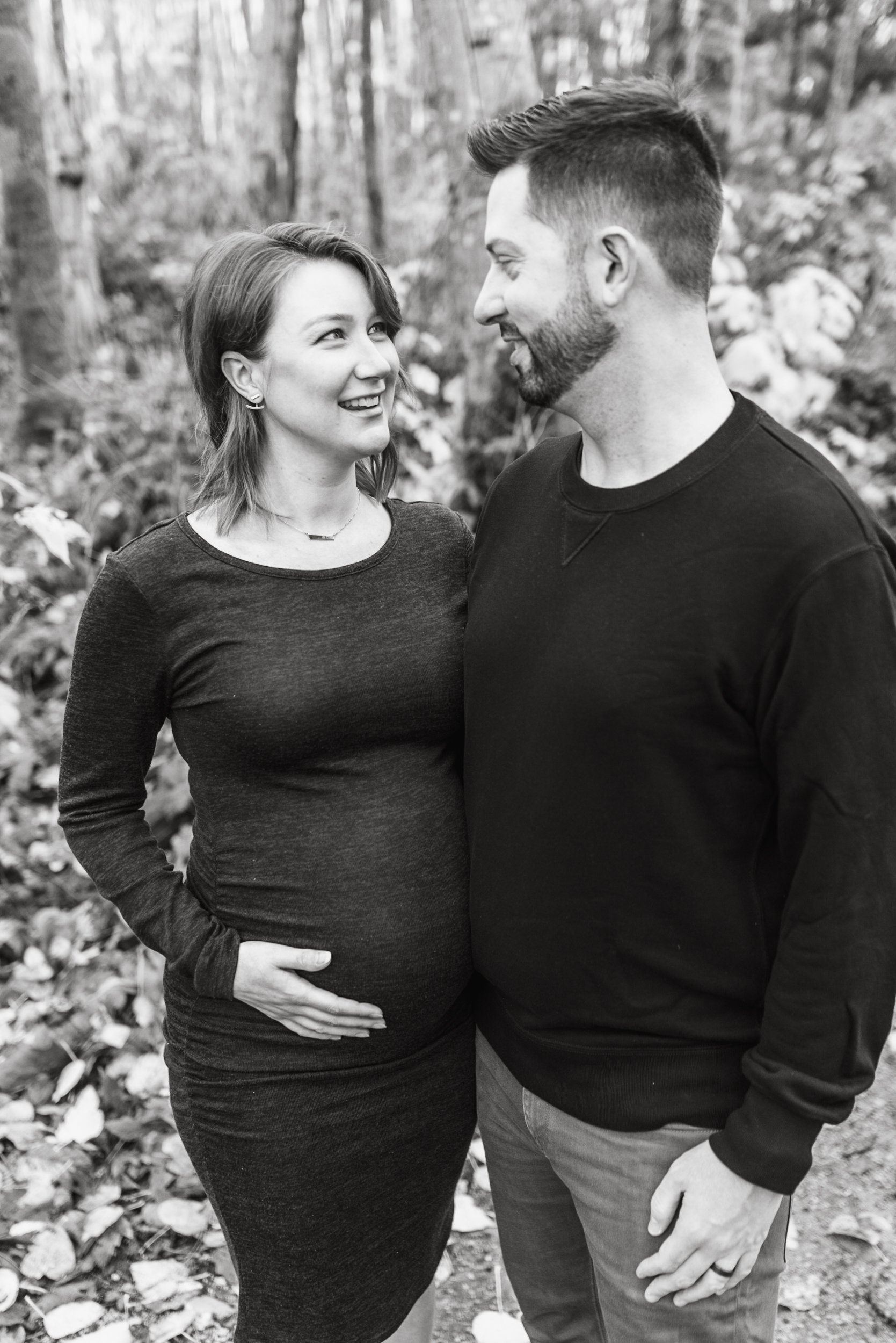 Pregnant woman with husband in forest black and white