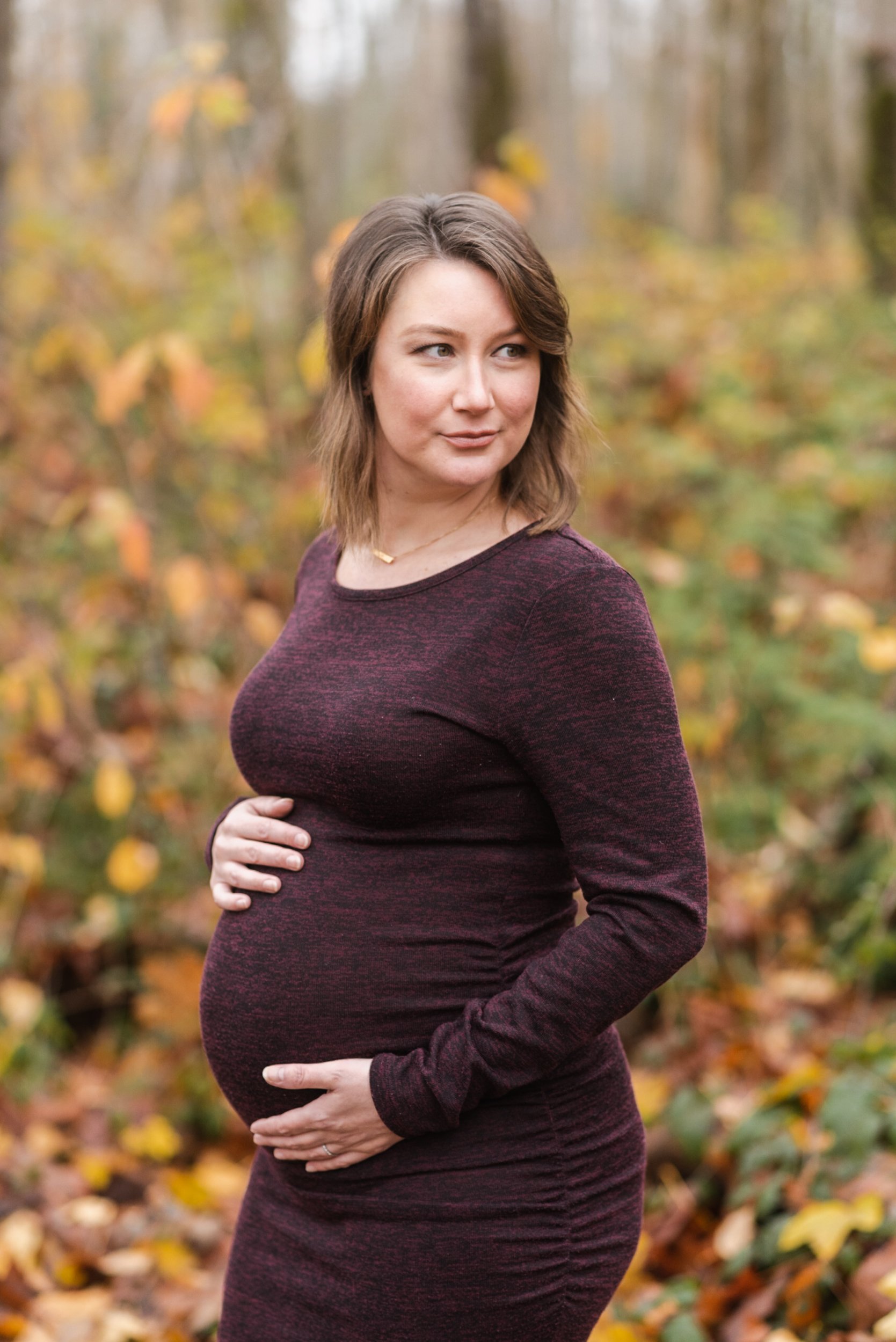 Pregnant woman burgundy dress in forest