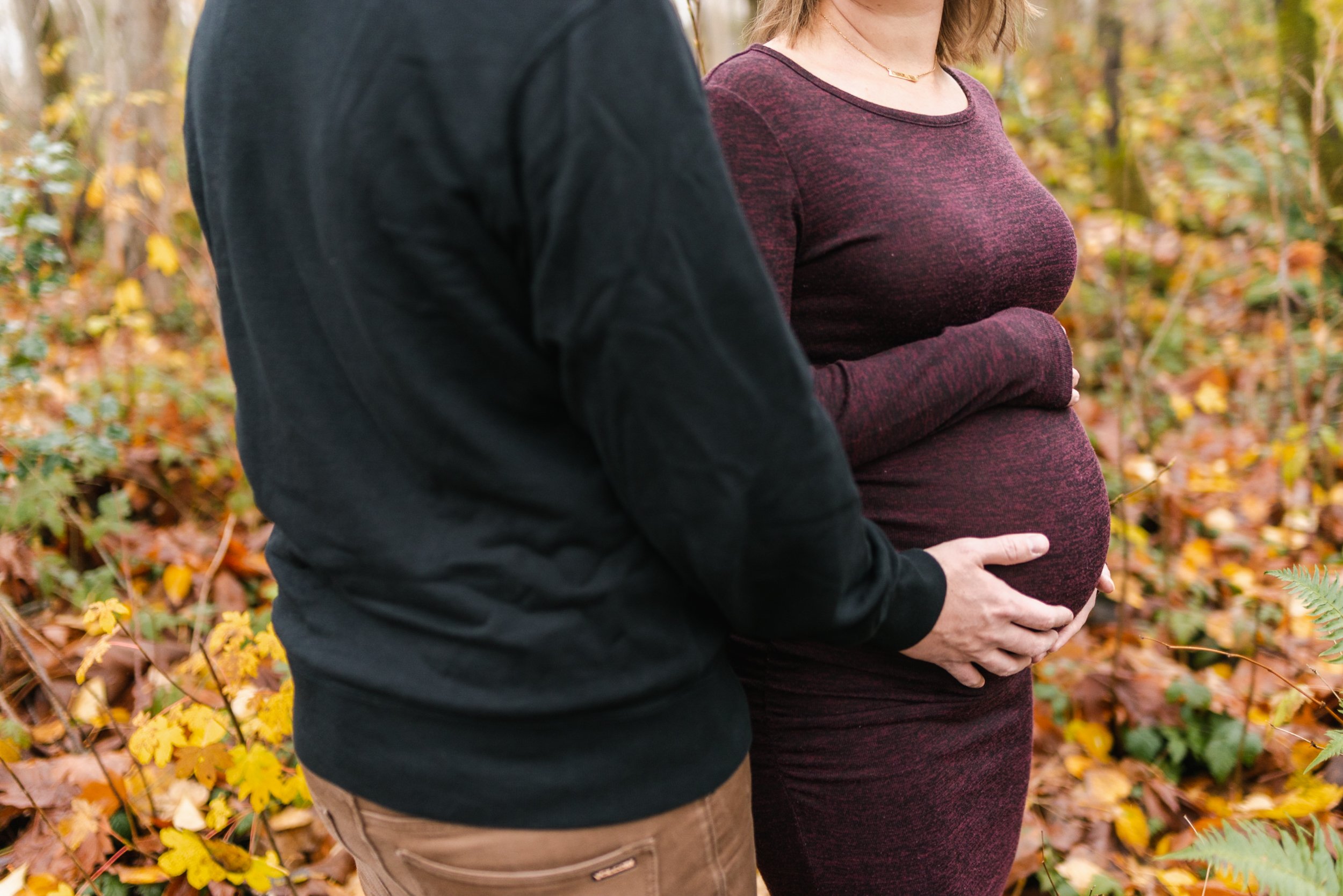 Husband holds belly of pregnant wife